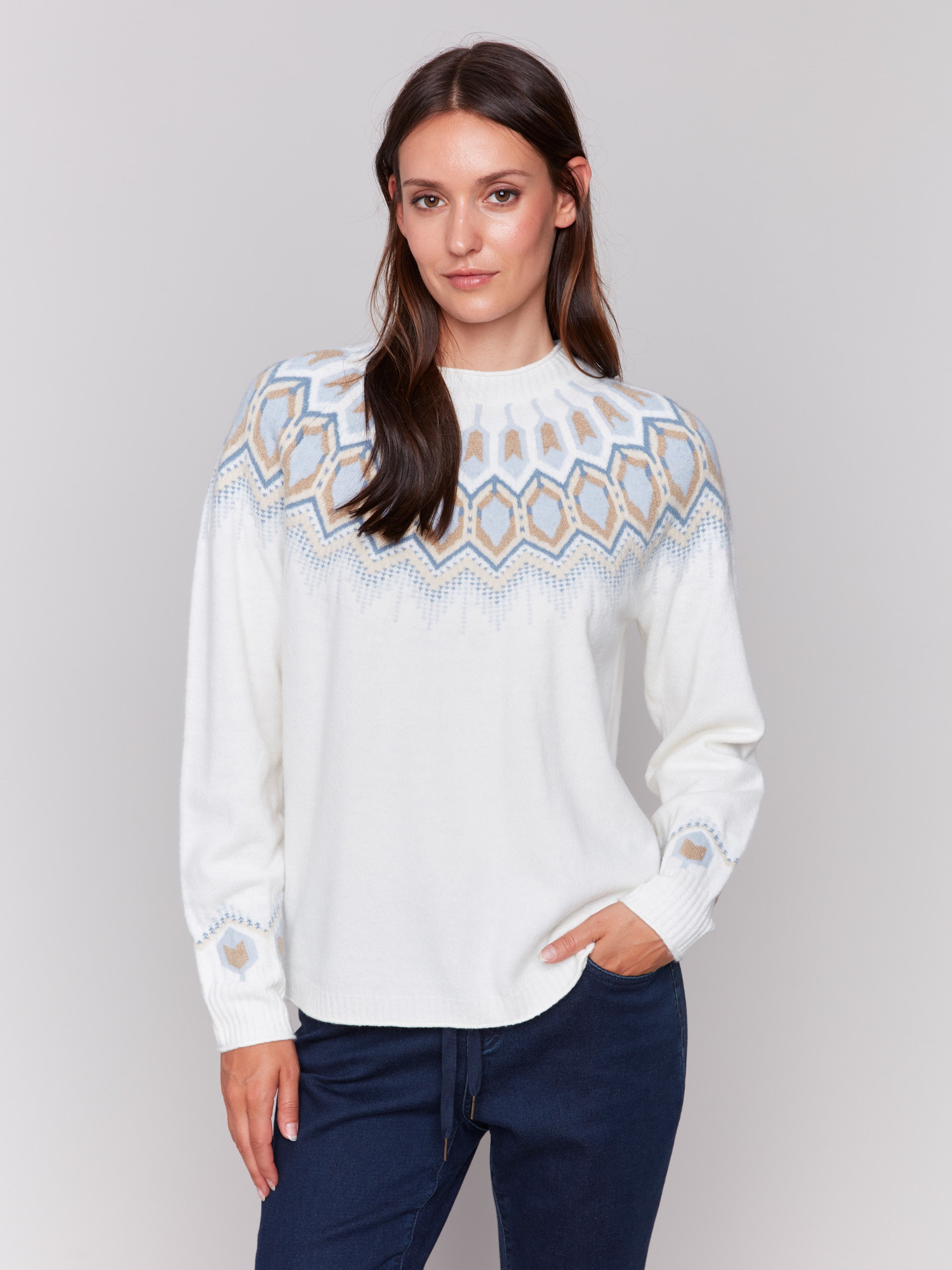 Cream white long-sleeve ski sweater with geometric jacquard patterns and raglan sleeves by Charlie B.