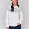 Cream white long-sleeve ski sweater with geometric jacquard patterns and raglan sleeves by Charlie B.