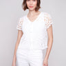 White cardigan with a V-neck and elegant crochet design by Charlie B.