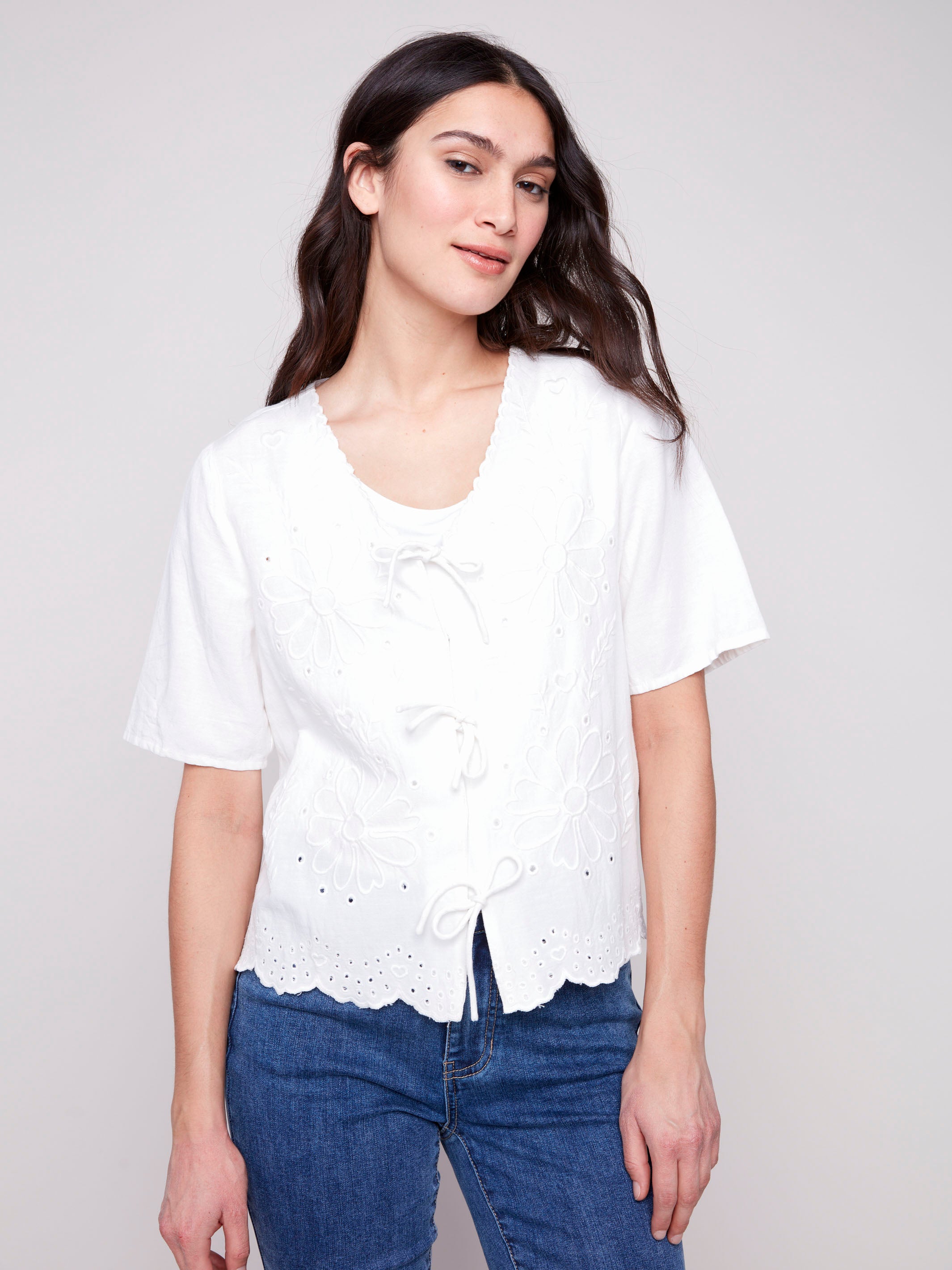 Elegant short sleeves with intricate embroidery on a white blouse by Charlie B.