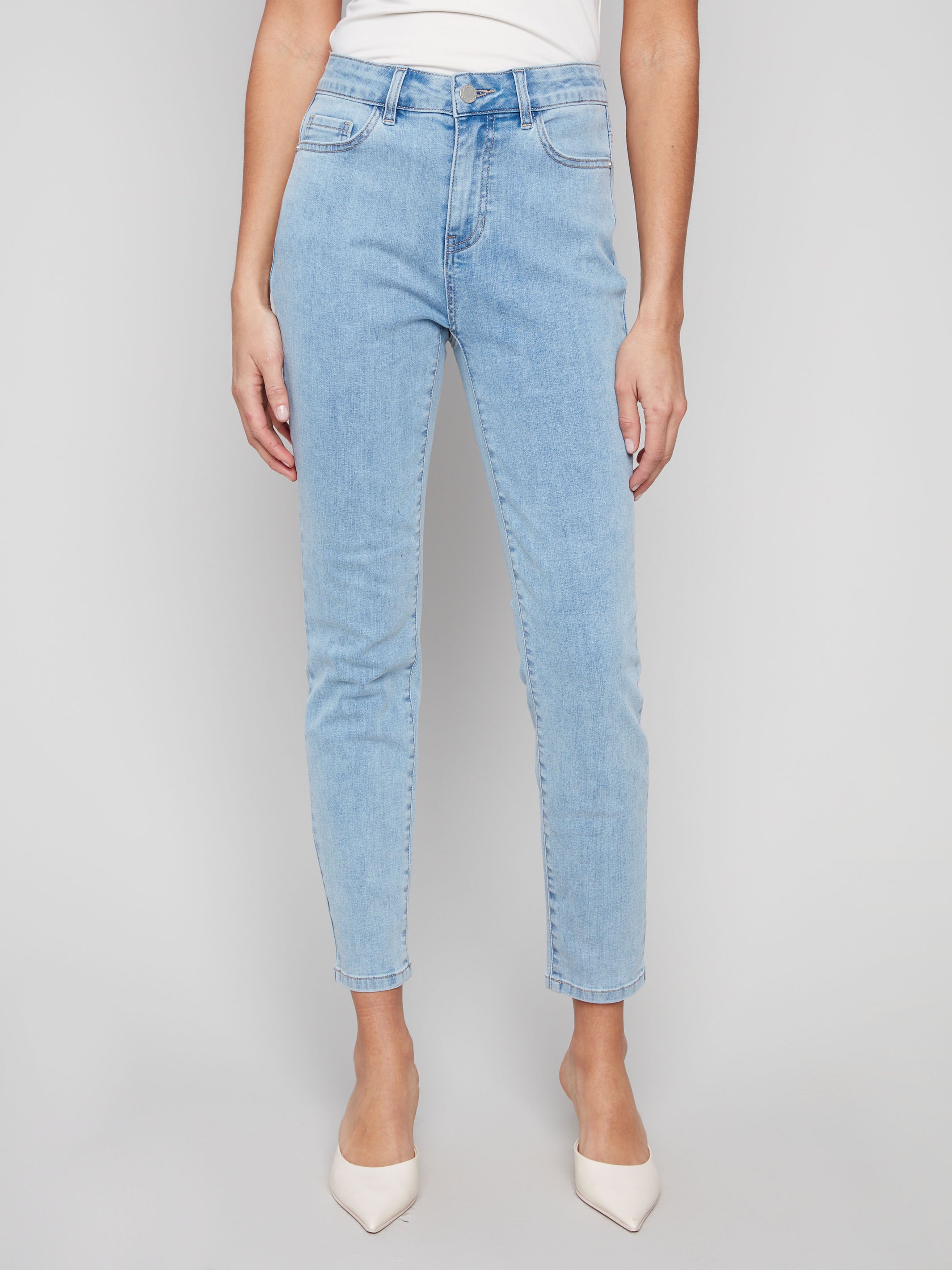 Light blue slim leg jeans with five-pocket design and button closure by Charlie B.