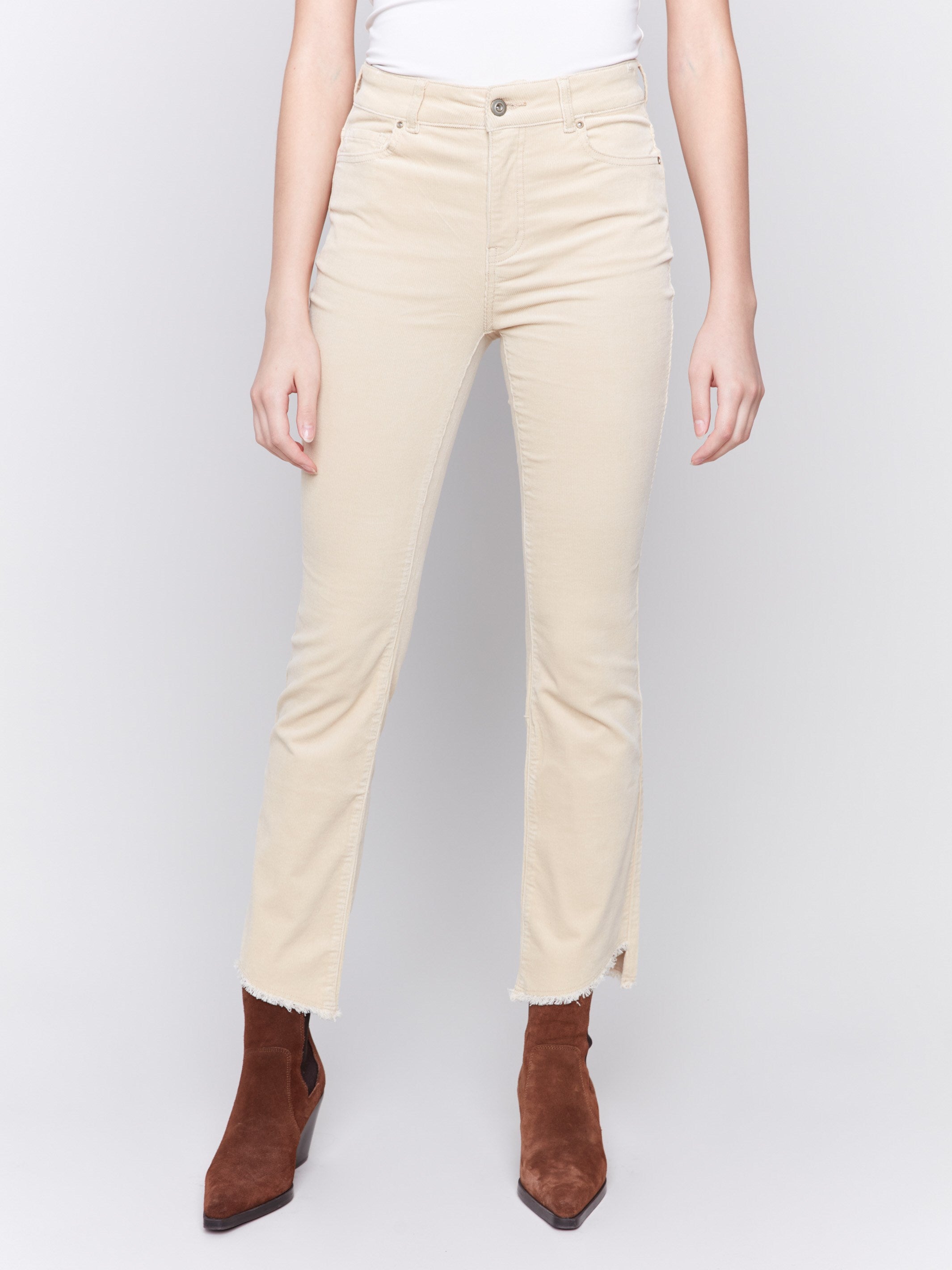 Natural-colored bootcut corduroy pants with an asymmetrical frayed hem and a bootcut fit by Charlie B.