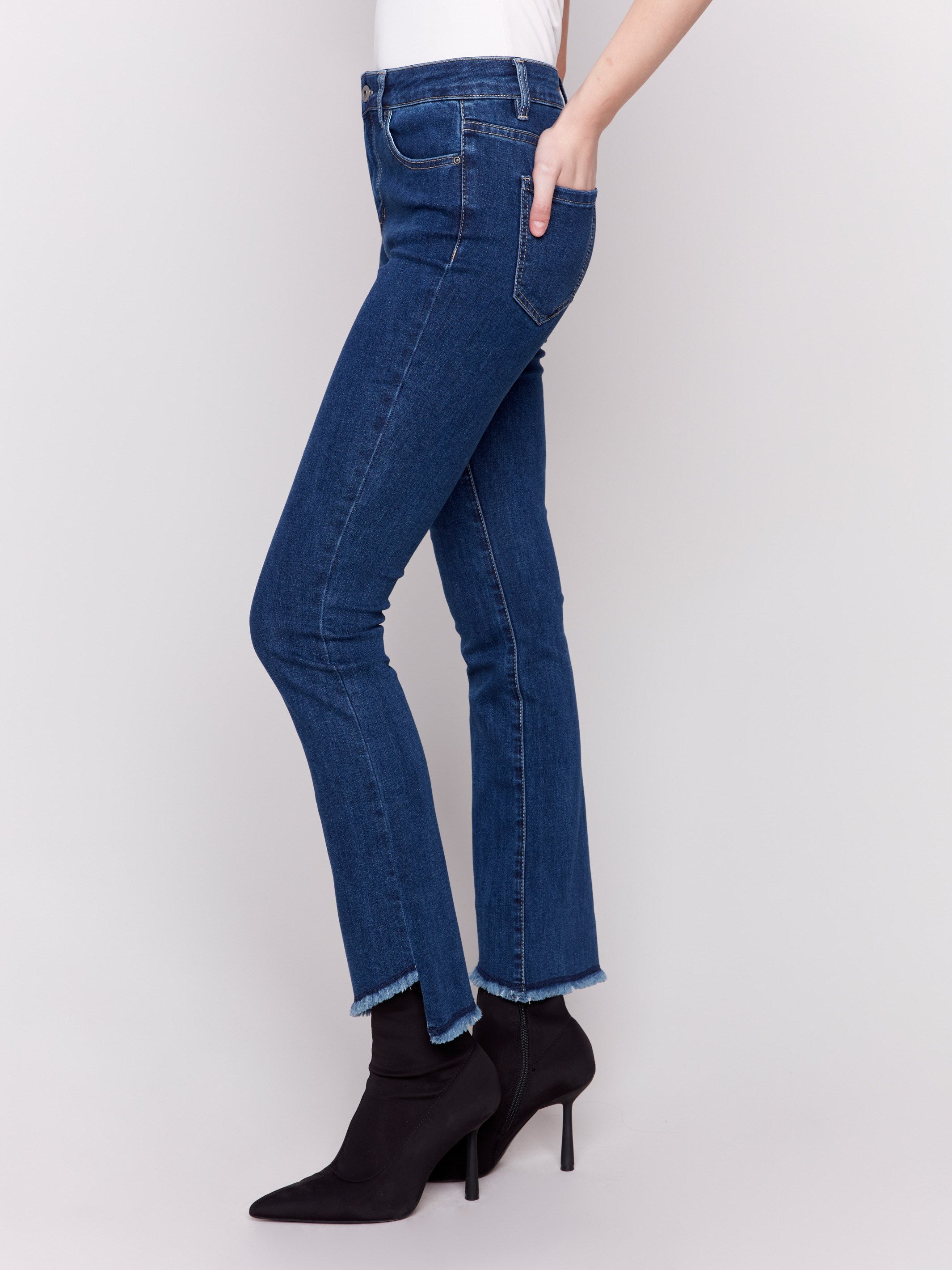 Indigo blue bootcut jeans with an asymmetrical frayed hem and bootcut fit design by Charlie B.