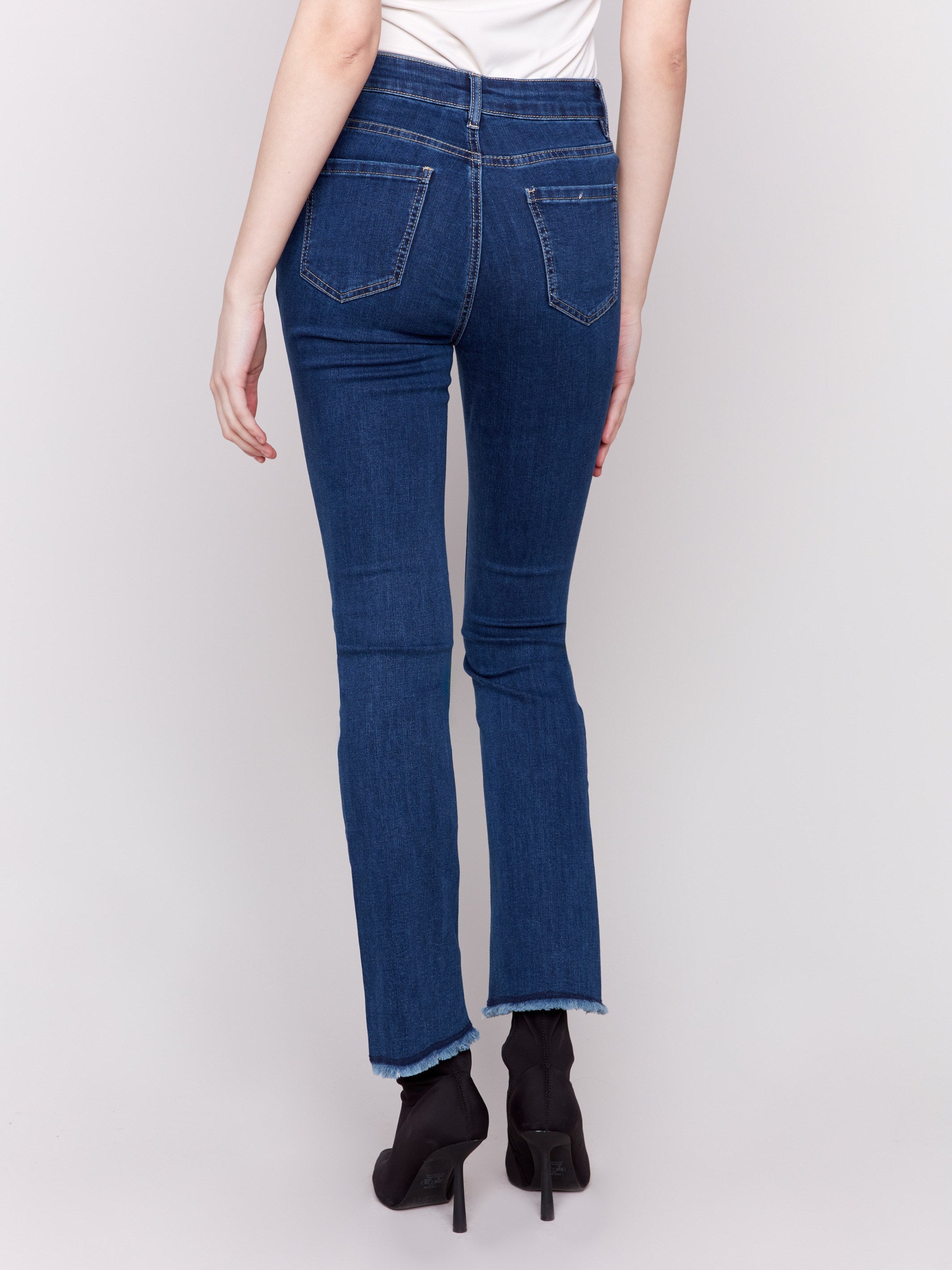 Indigo blue bootcut jeans with an asymmetrical frayed hem and bootcut fit design by Charlie B.