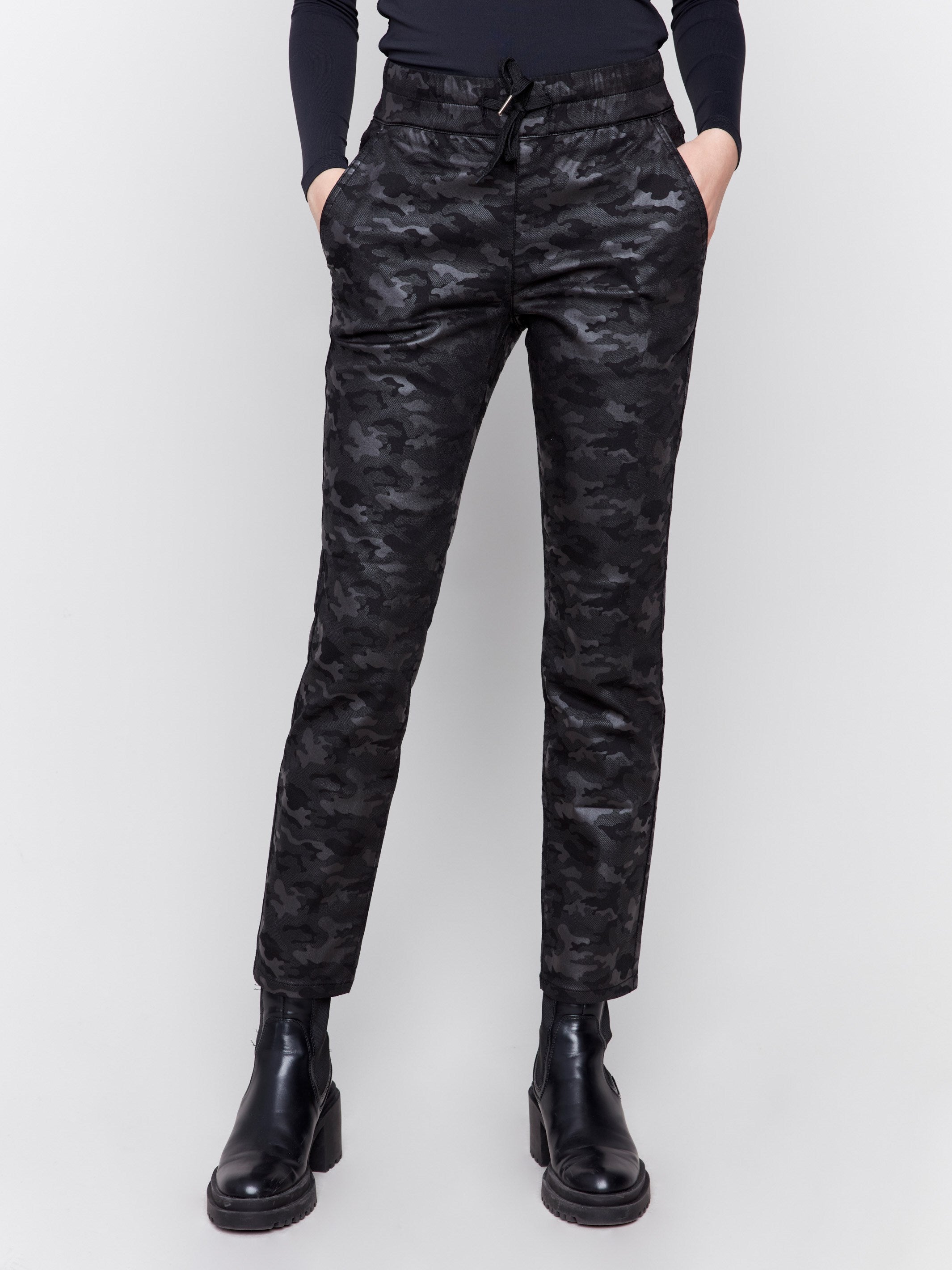 Black camouflage print jogger pants featuring slim legs, an elastic waistband with drawstring, and front pockets by Charlie B.