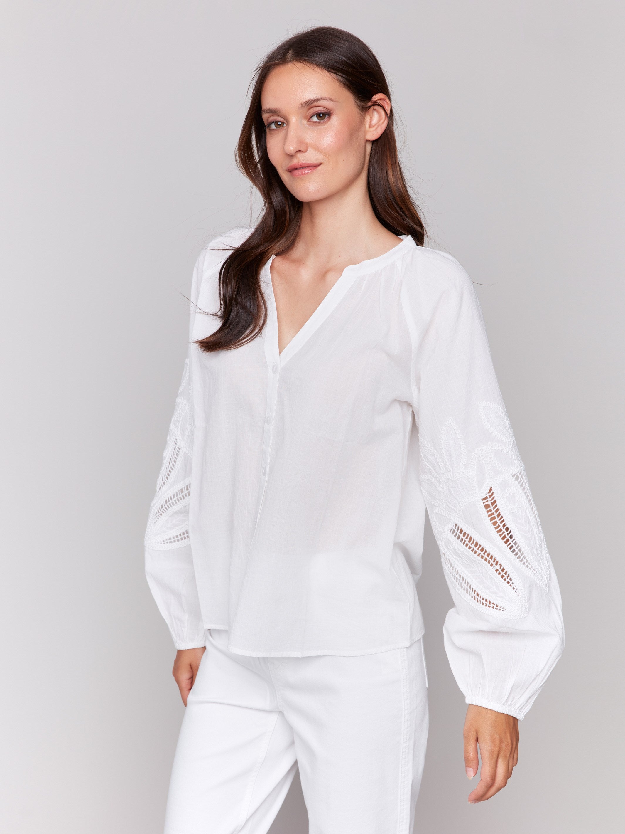 Button-front closure on elegant white blouse by Charlie B.