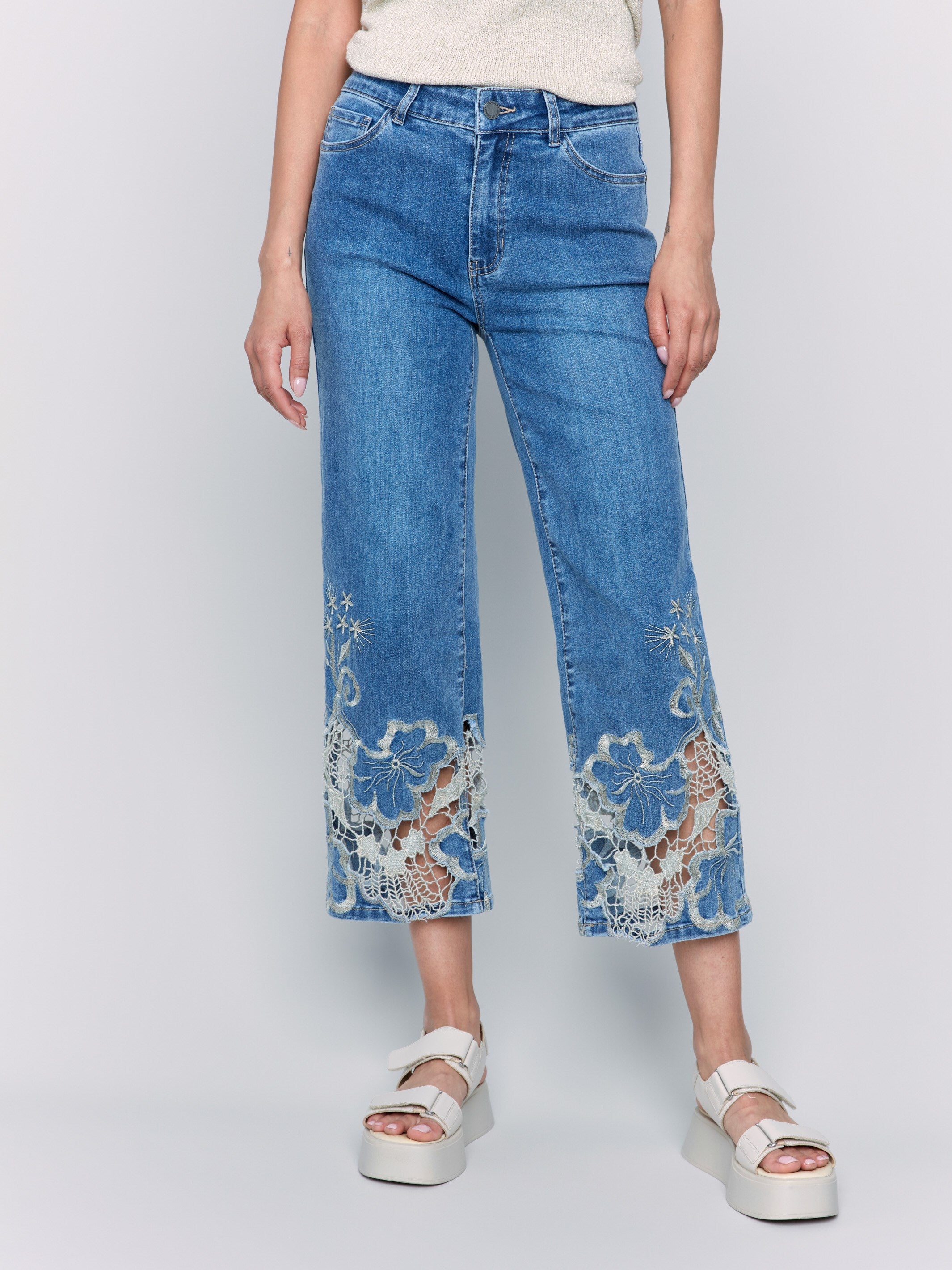 Cropped length medium blue jeans featuring a classic five-pocket design by Charlie B.