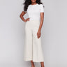 Beige cropped wide-leg pants with a side zipper, styled with a white top and beige heels by Charlie B.