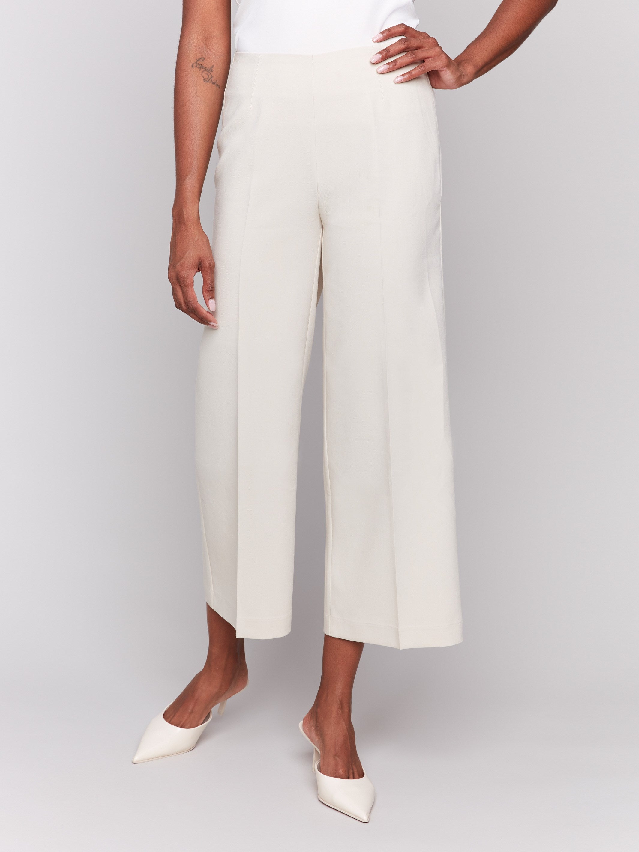 Beige cropped wide-leg pants with a side zipper, styled with a white top and beige heels by Charlie B.