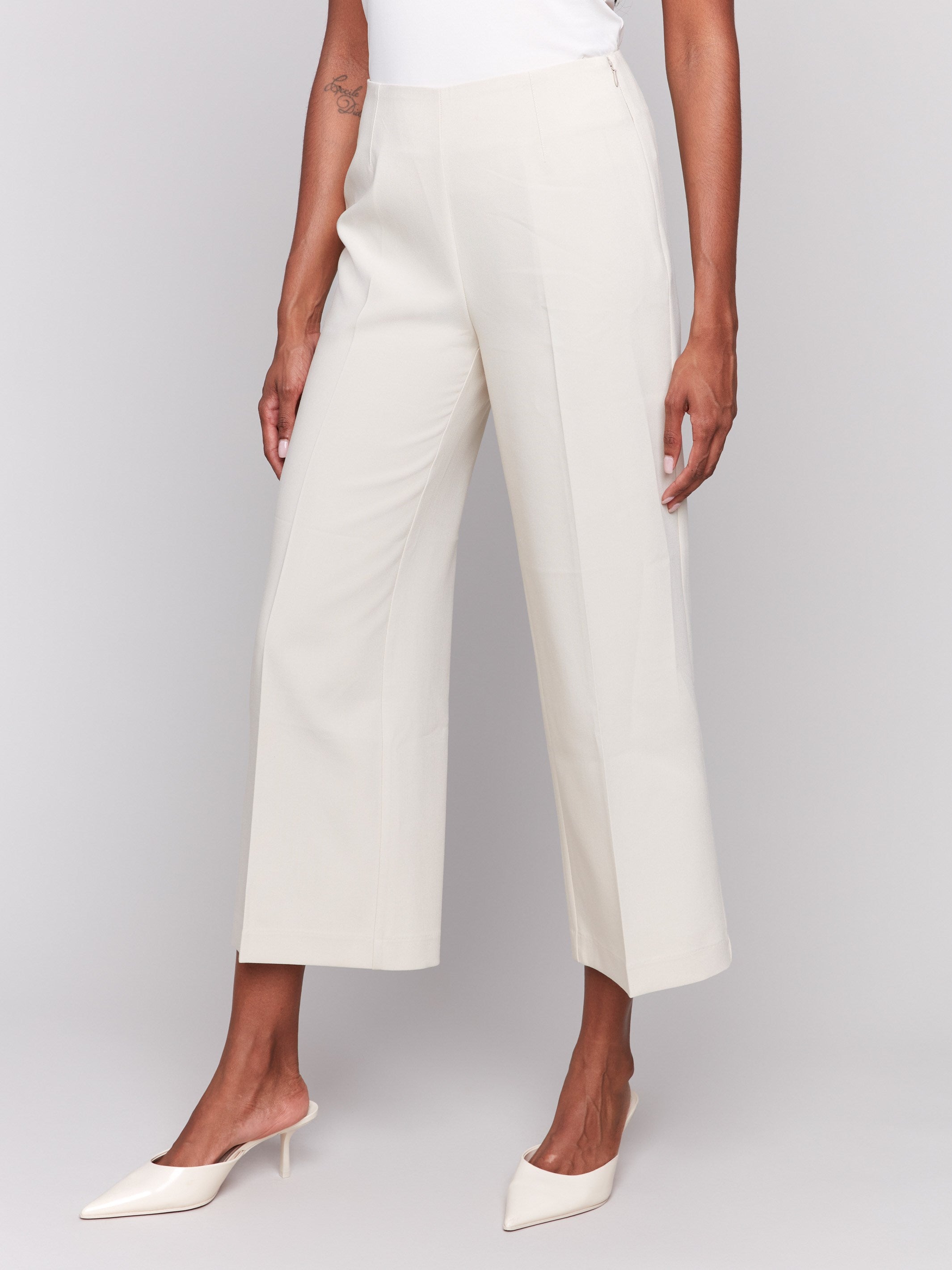 Beige cropped wide-leg pants with a side zipper, styled with a white top and beige heels by Charlie B.