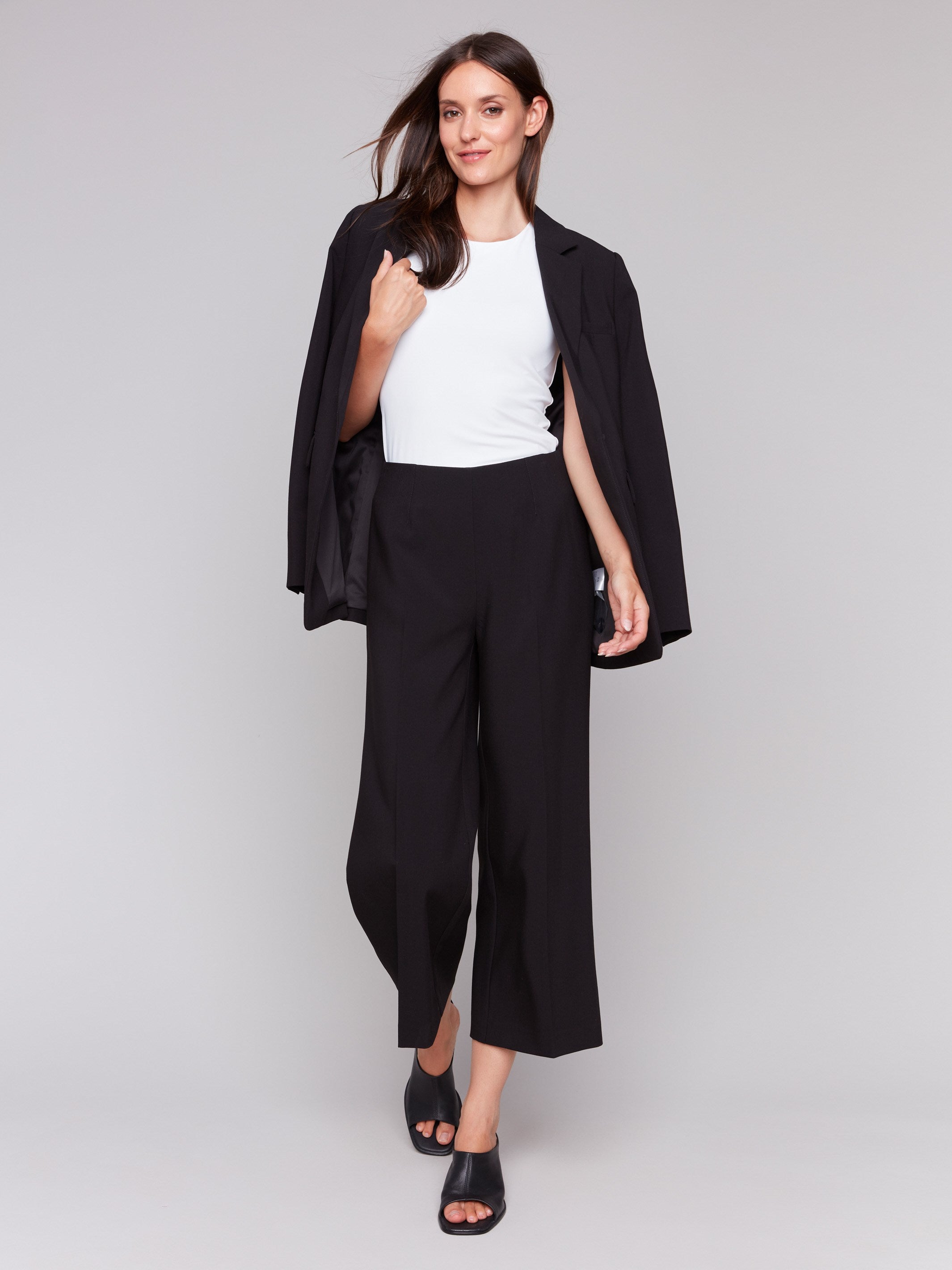 Black cropped wide-leg pants with a side zipper, worn by a model in a white top, by Charlie B.