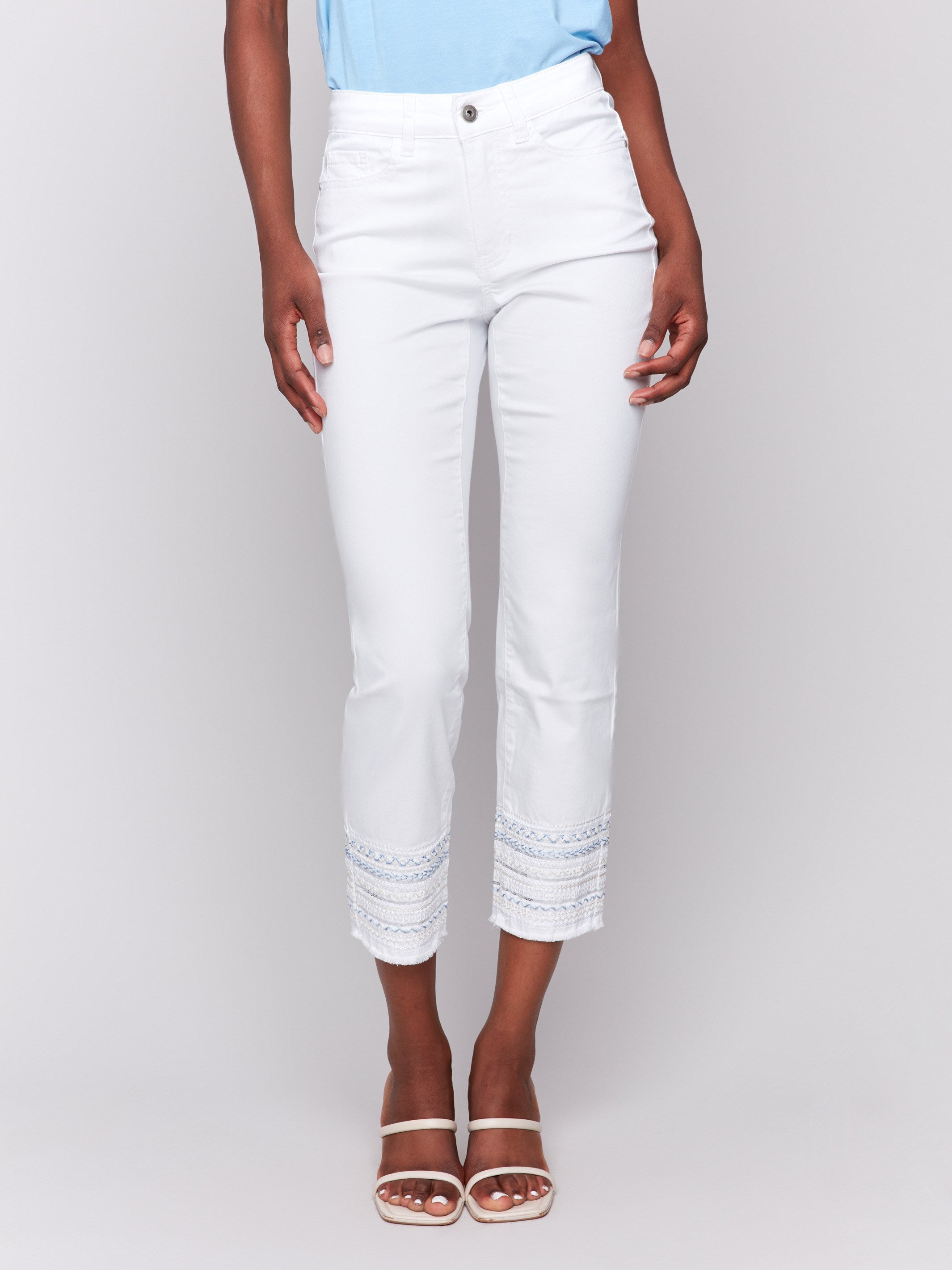 White slim-leg jeans with an embroidered hem and classic five-pocket design by Charlie B.