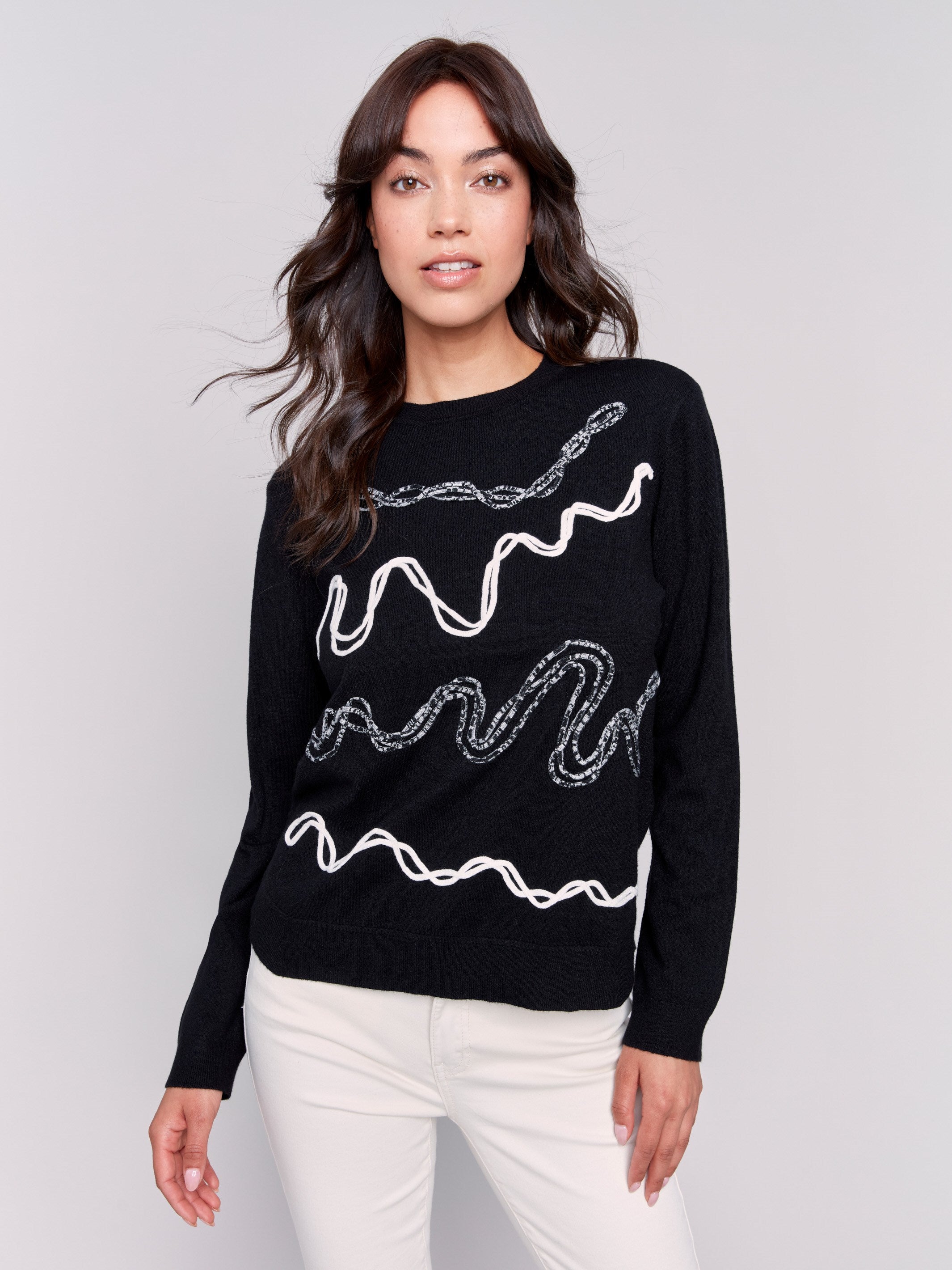 Black jacquard knit sweater featuring abstract embroidery and a round hemline by Charlie B.