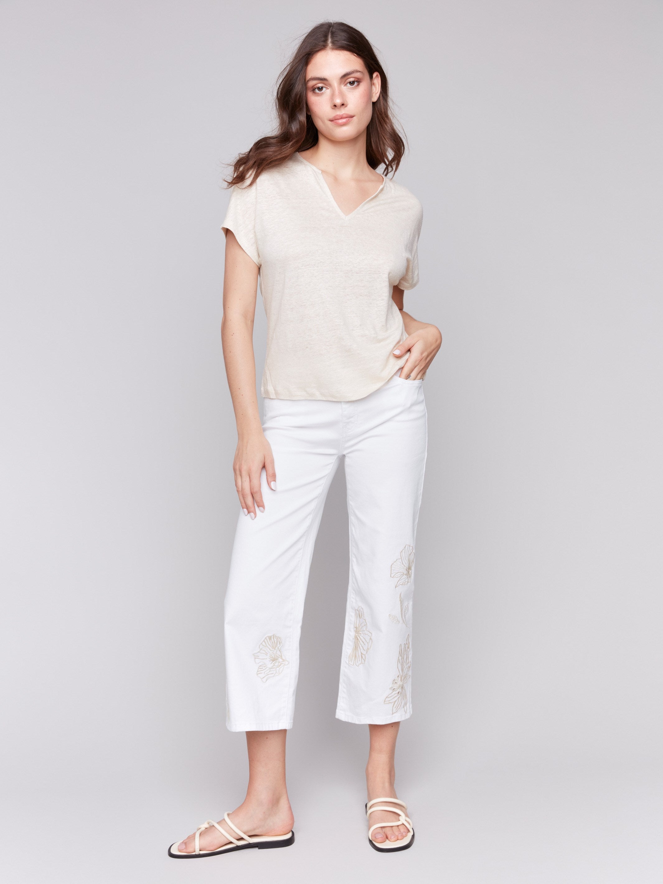 White twill pants with a flare fit and floral embroidery by Charlie B.