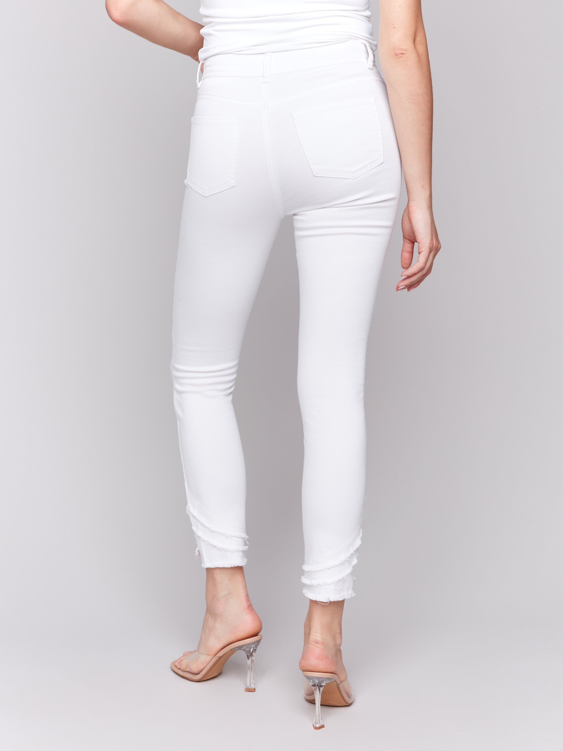 White slim fit twill pants with a frayed hem, ankle-length and mid-rise design by Charlie B.