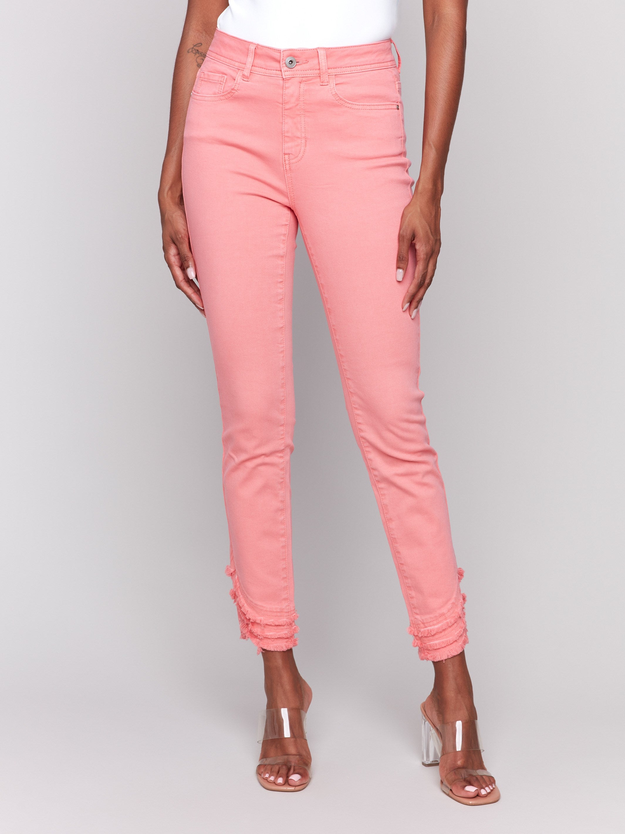 Watermelon-colored slim fit twill pants with a frayed hem, ankle-length and mid-rise design by Charlie B.