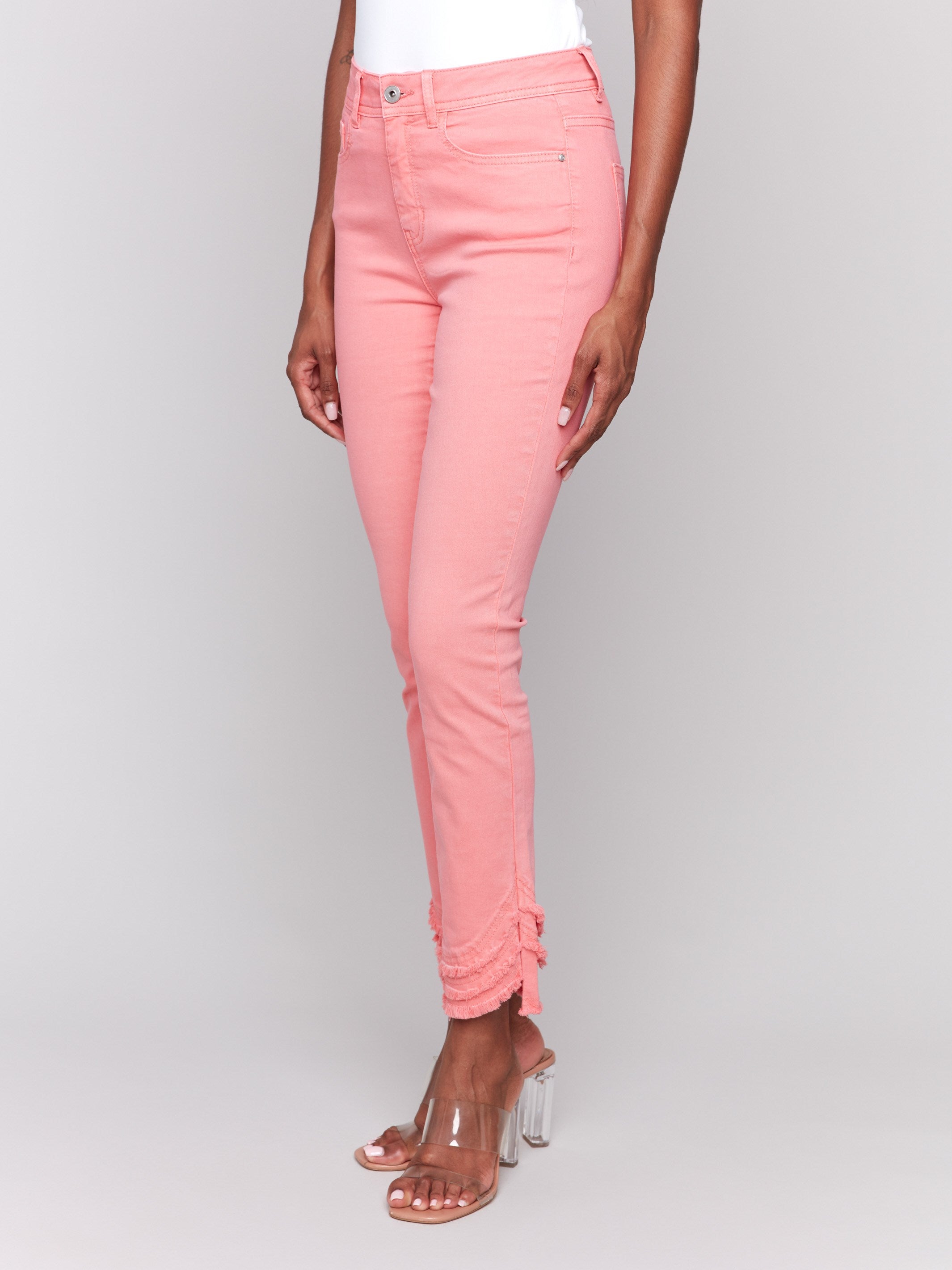 Watermelon-colored slim fit twill pants with a frayed hem, ankle-length and mid-rise design by Charlie B.