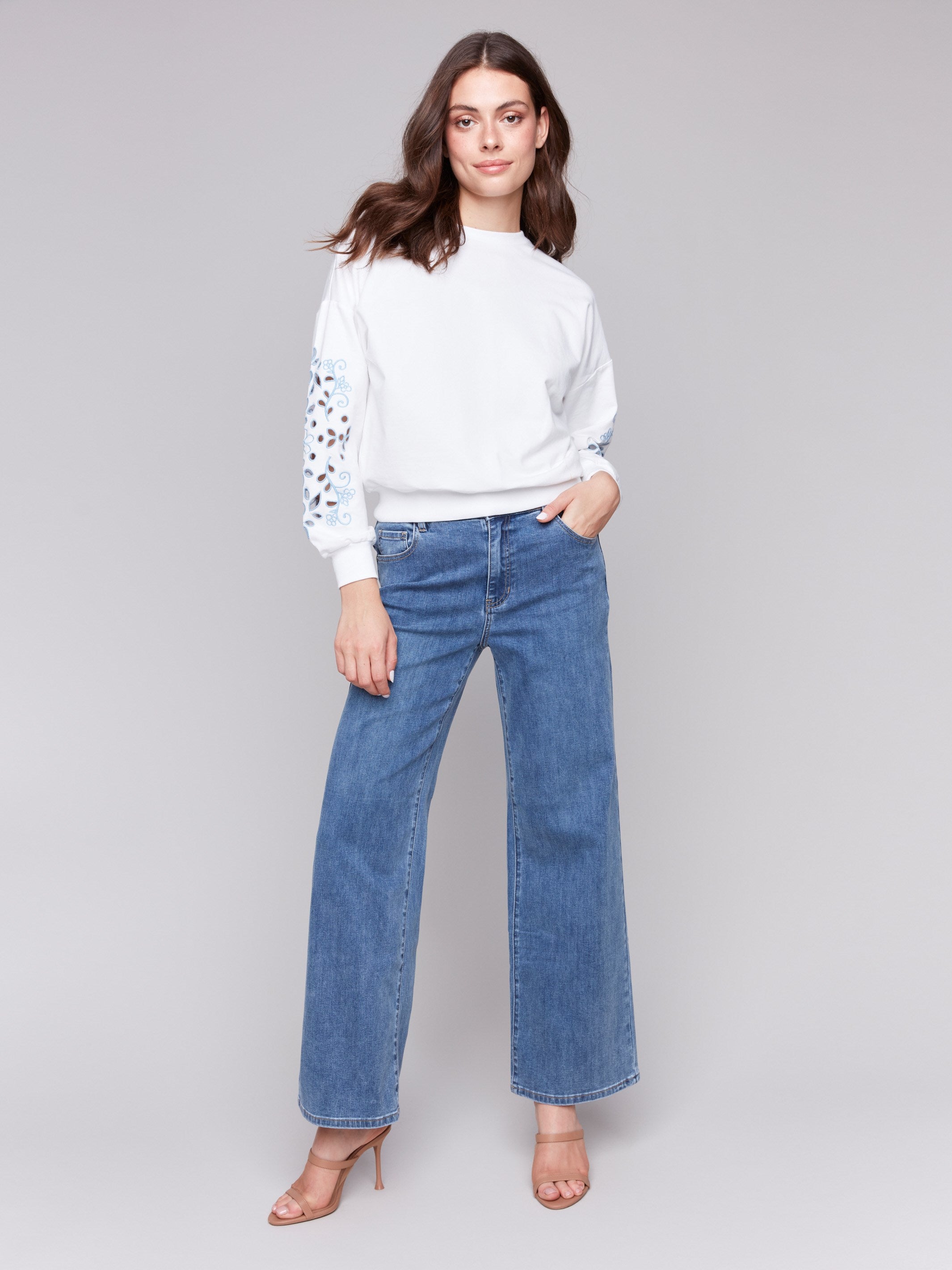 Embroidered sleeves on a stylish white sweatshirt, designed for comfort by Charlie B.