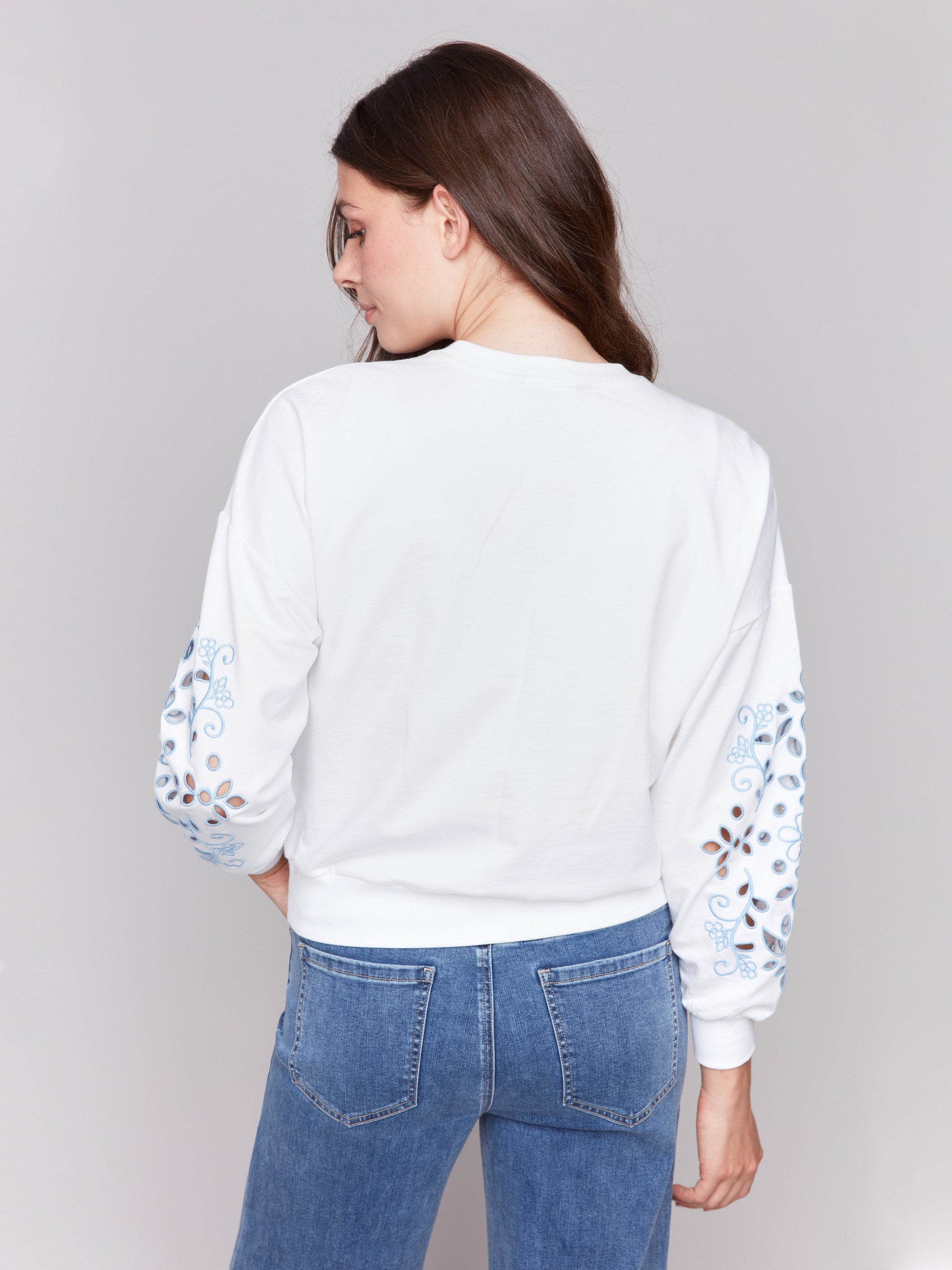 Long embroidered sleeves elevate this chic white sweatshirt by Charlie B.