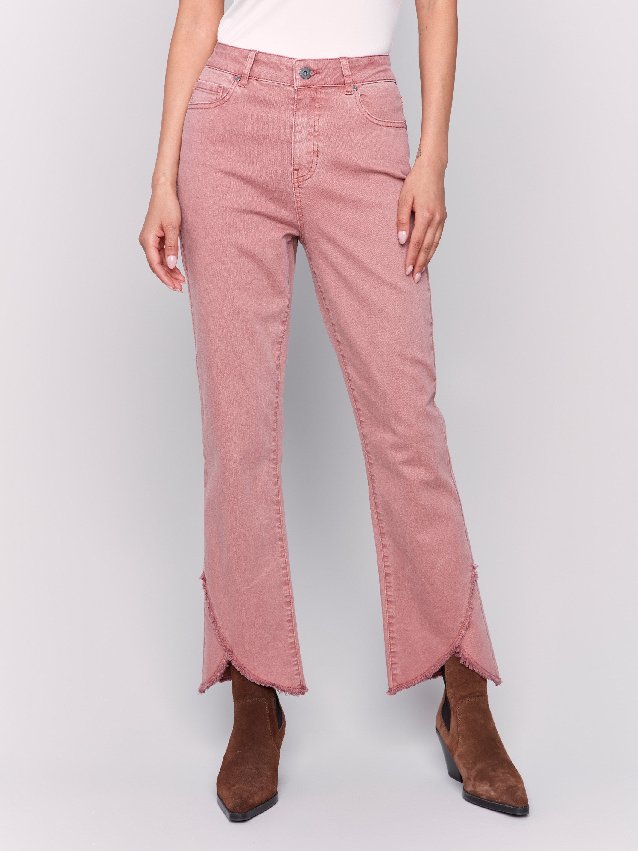 Woodrose pink front tulip hem twill pants featuring a mid-rise and bootcut leg. Unique front tulip hem detail for a stylish look by Charlie B.