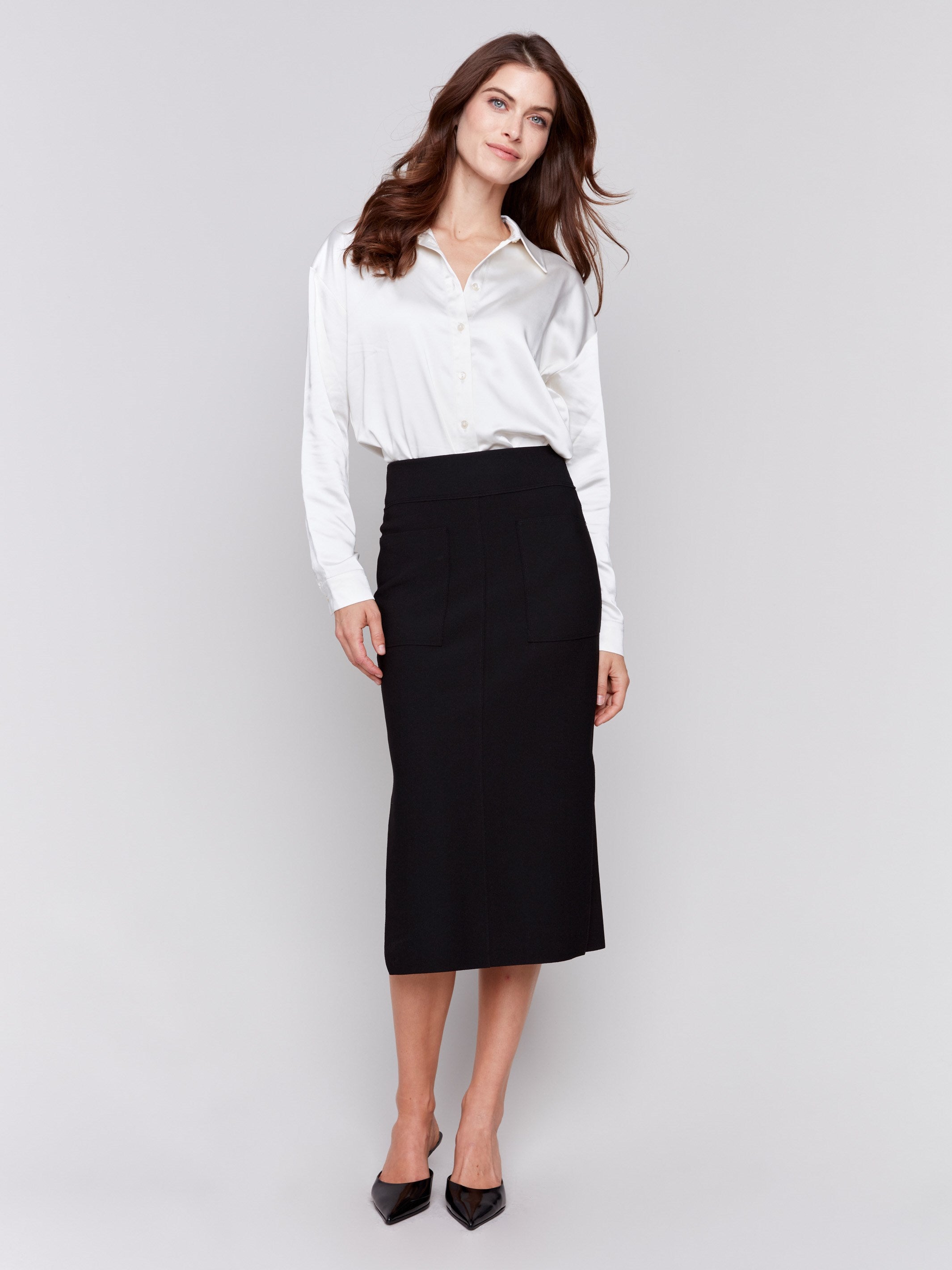 Elegant black gutsy crepe midi skirt with front patch pockets, featuring a side slit and a sleek, polished look by Charlie B.