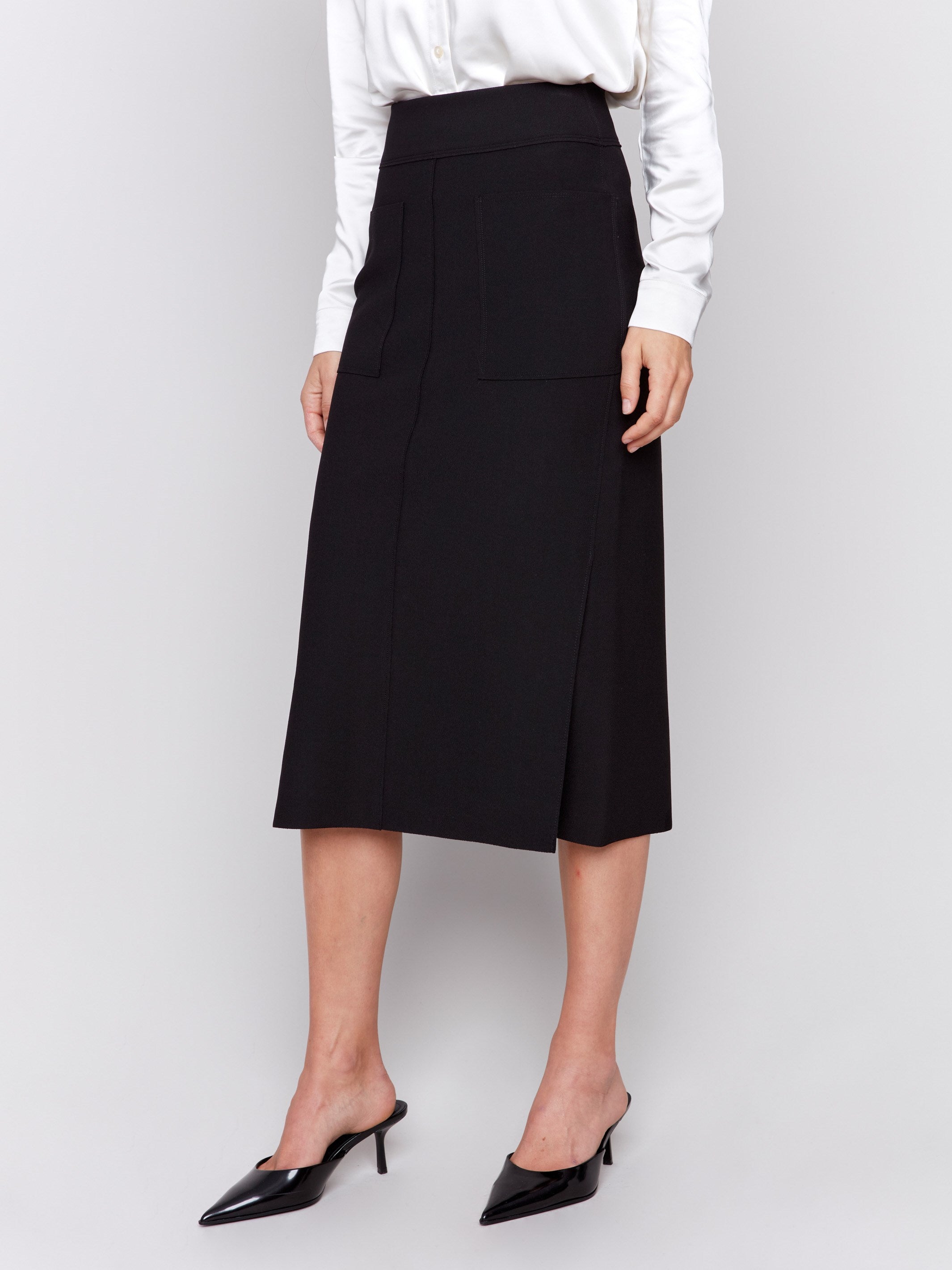 Elegant black gutsy crepe midi skirt with front patch pockets, featuring a side slit and a sleek, polished look by Charlie B.