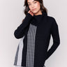 Black sweater with a houndstooth stripe, featuring a cowl neck and side slit by Charlie B.