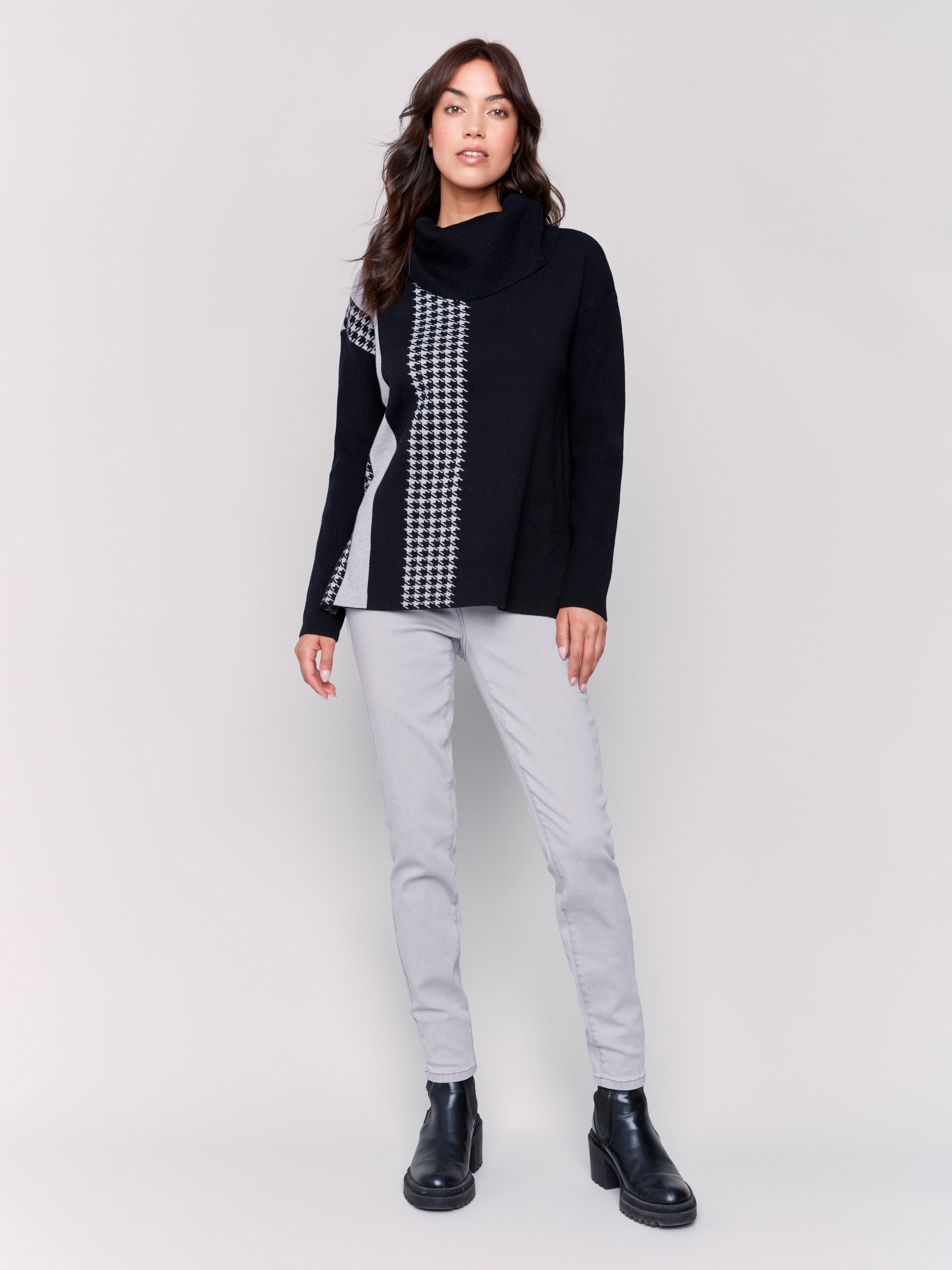 Black sweater with a houndstooth stripe, featuring a cowl neck and side slit by Charlie B.