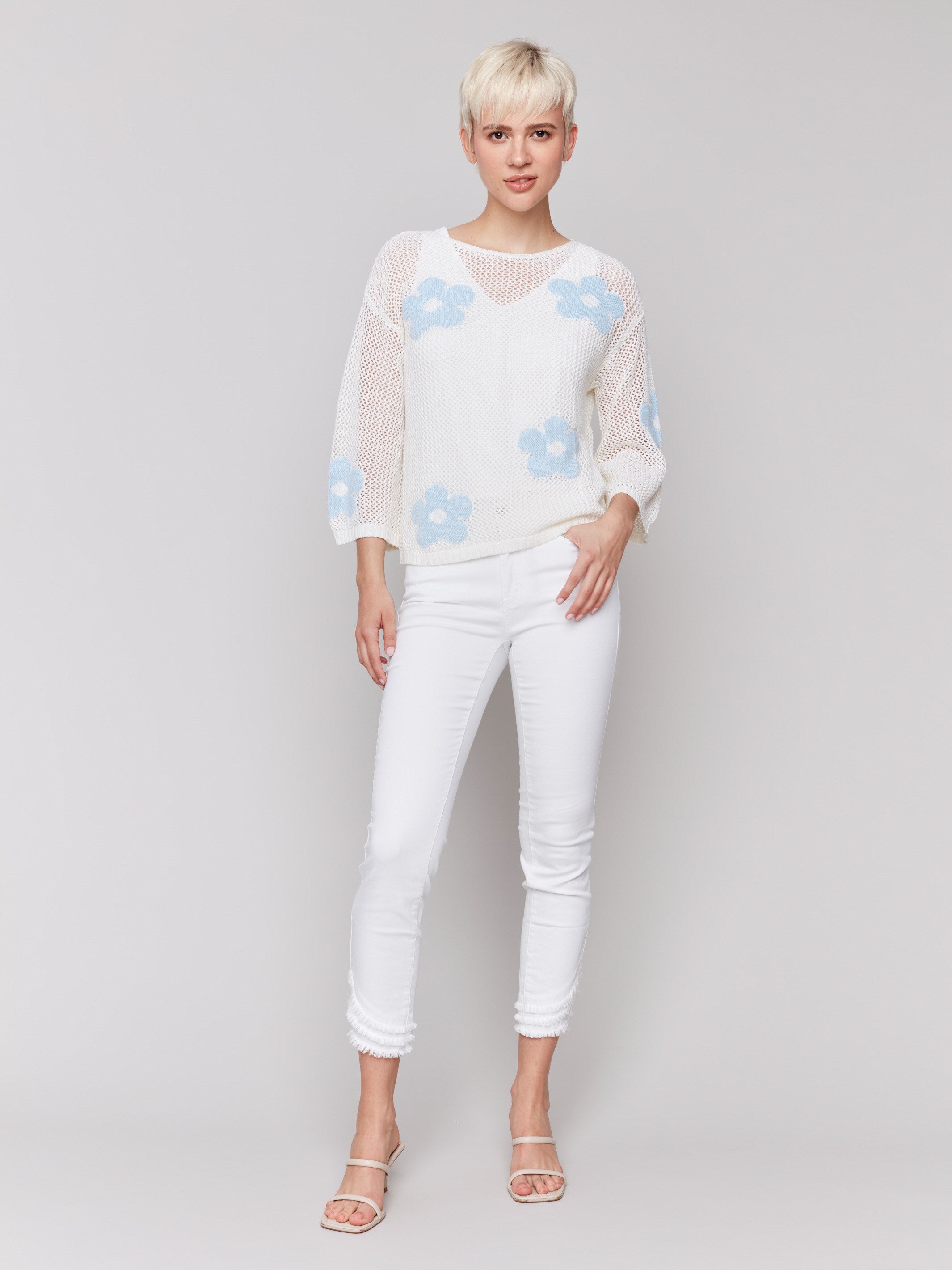 Elegant white sweater with intricate crochet detailing and drop shoulder sleeves by Charlie B.