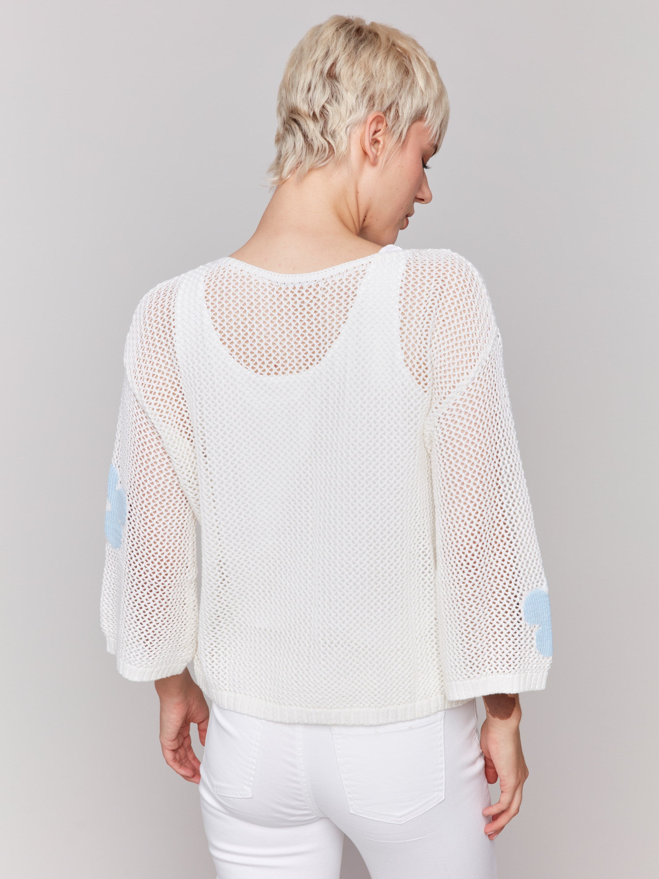 Stylish white crochet sweater highlighting a unique floral motif by Charlie B.