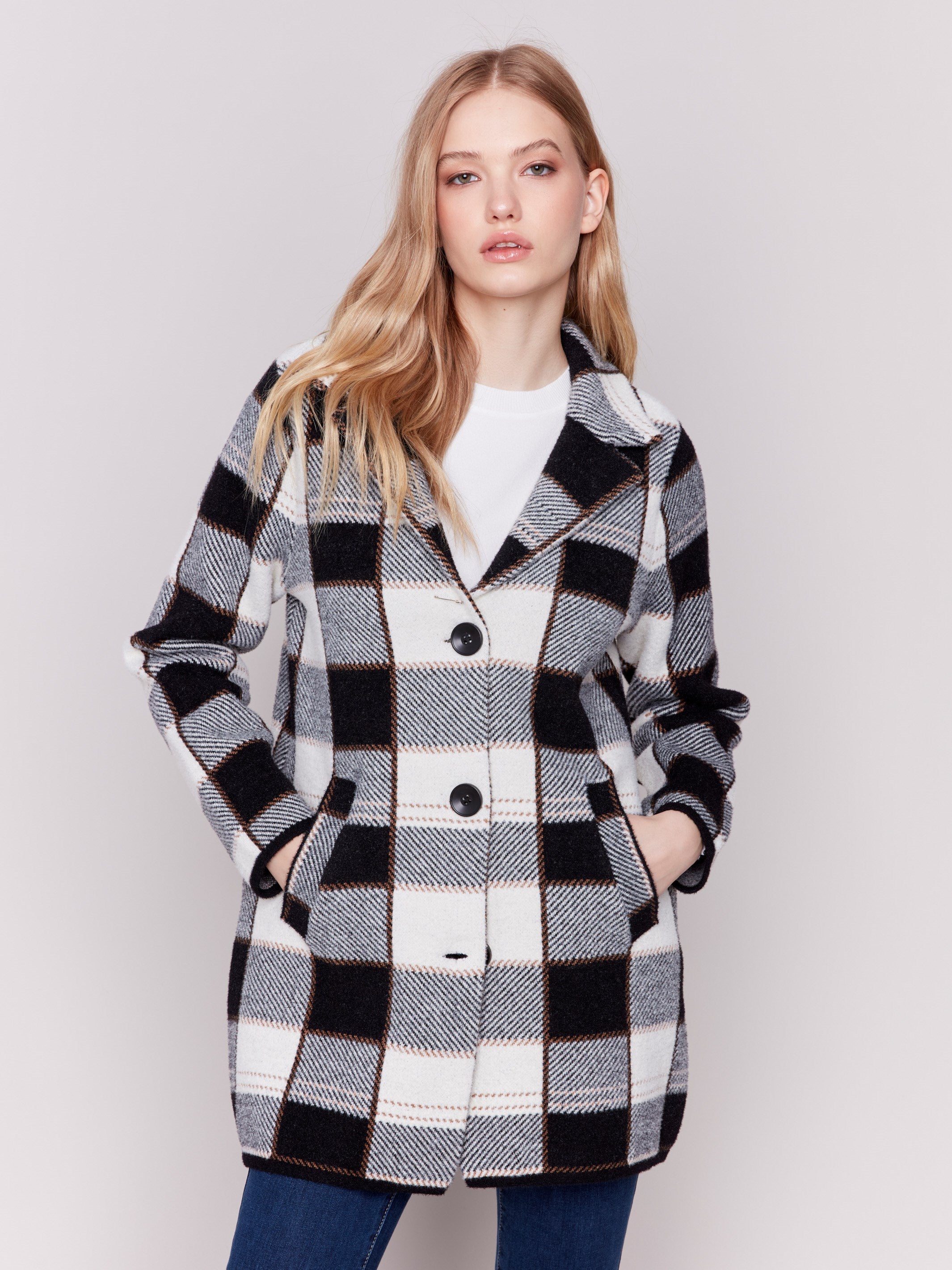 Women's plaid coat in black and white with a lapel notch collar, full button closure, and side welt pockets by Charlie B.