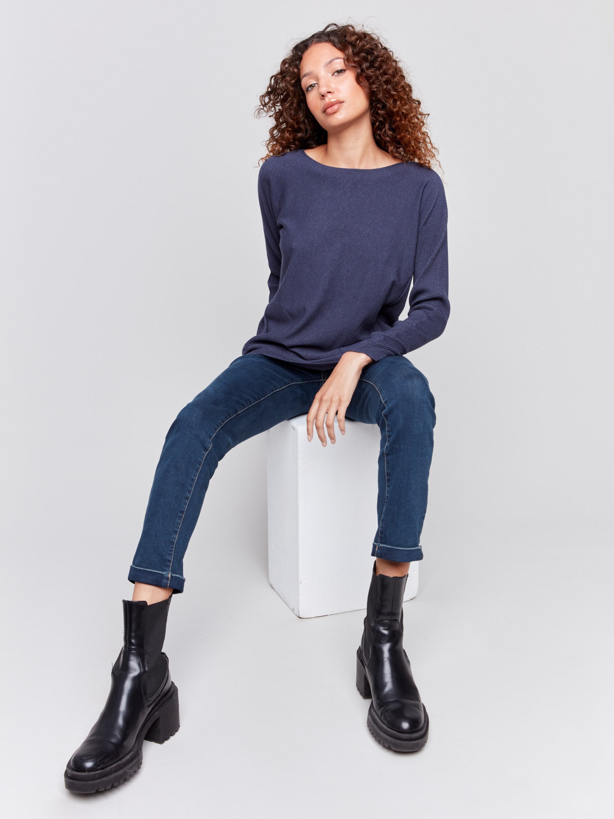 Dark blue knit sweater with a crew neckline, long ribbed sleeves, and back lace-up eyelet details by Charlie B.