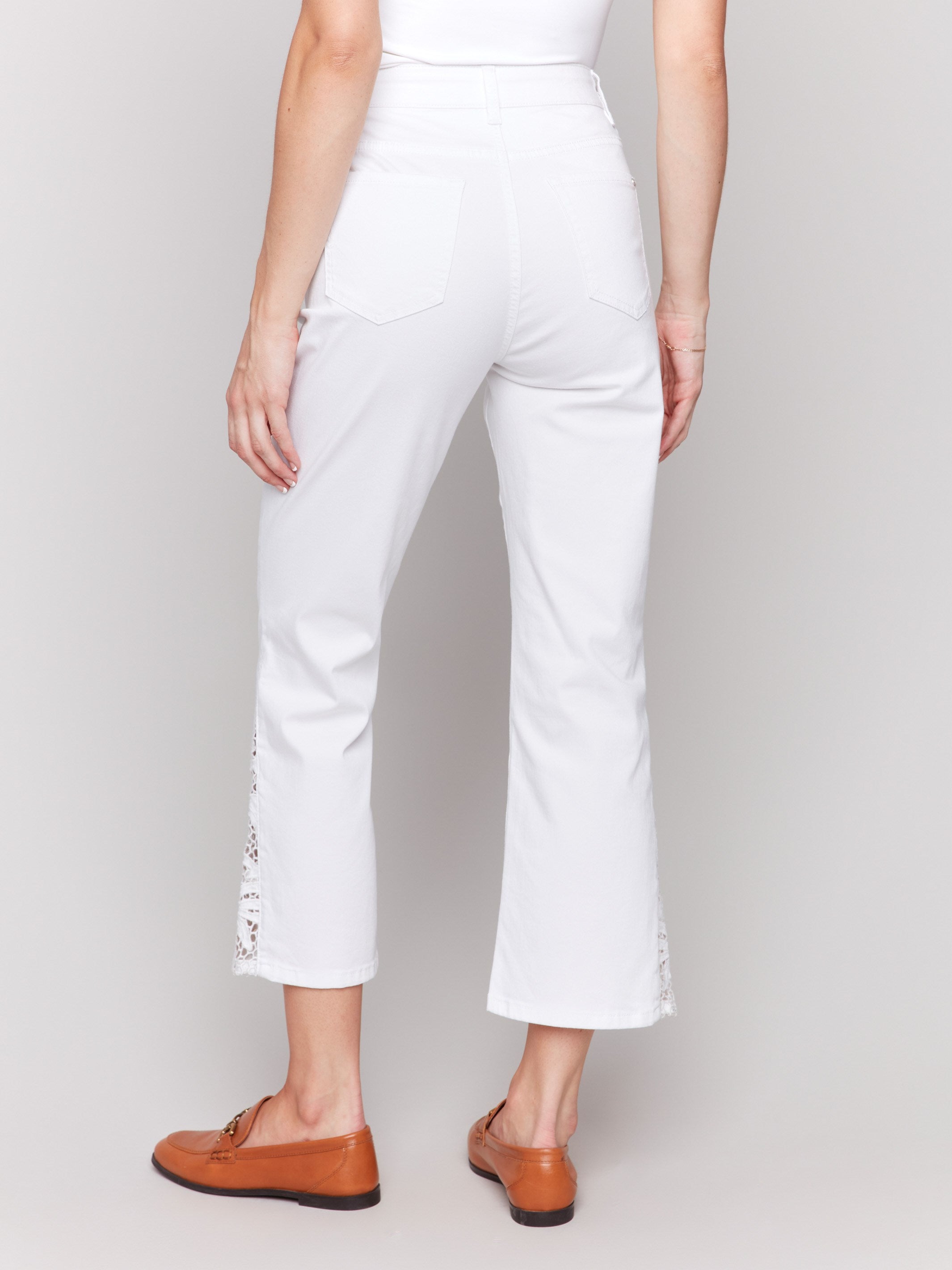 Elegant white pants with intricate lace detailing and bootcut fit by Charlie B.