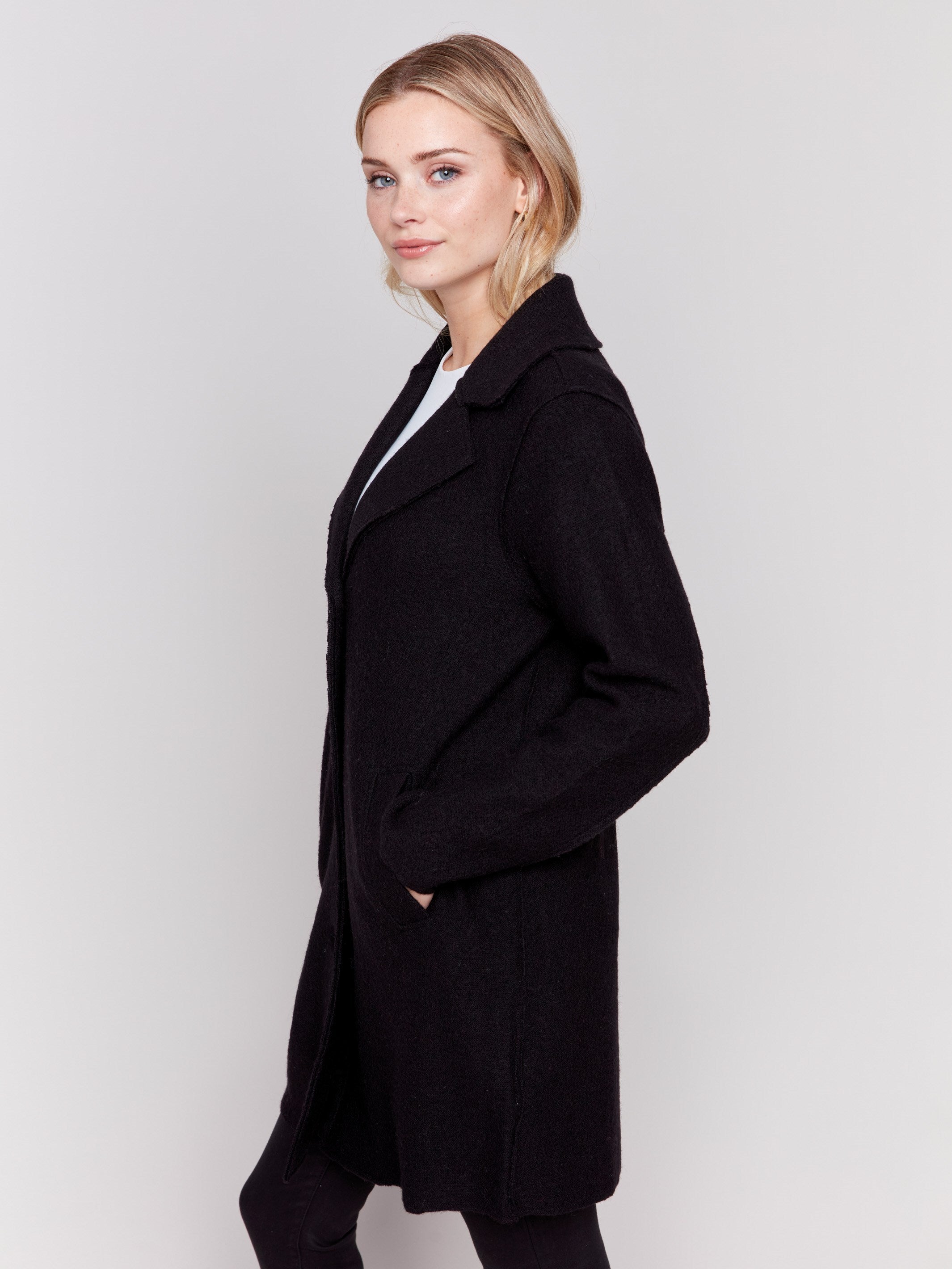 Black long wool coat with lapel notch collar and button closures, featuring front welt pockets by Charlie B.