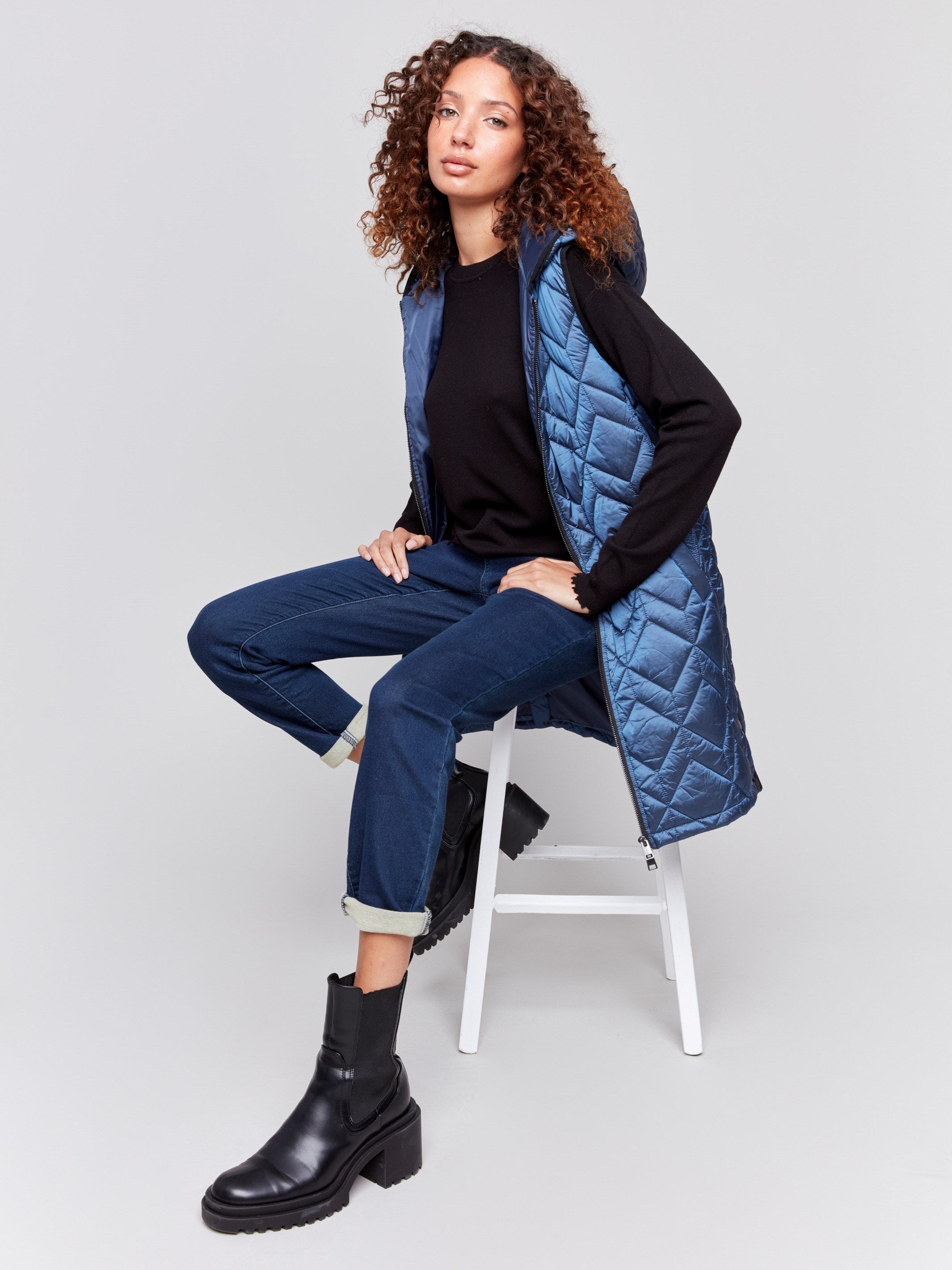 Navy blue long quilted puffer vest with hood and a zippered front by Charlie B.