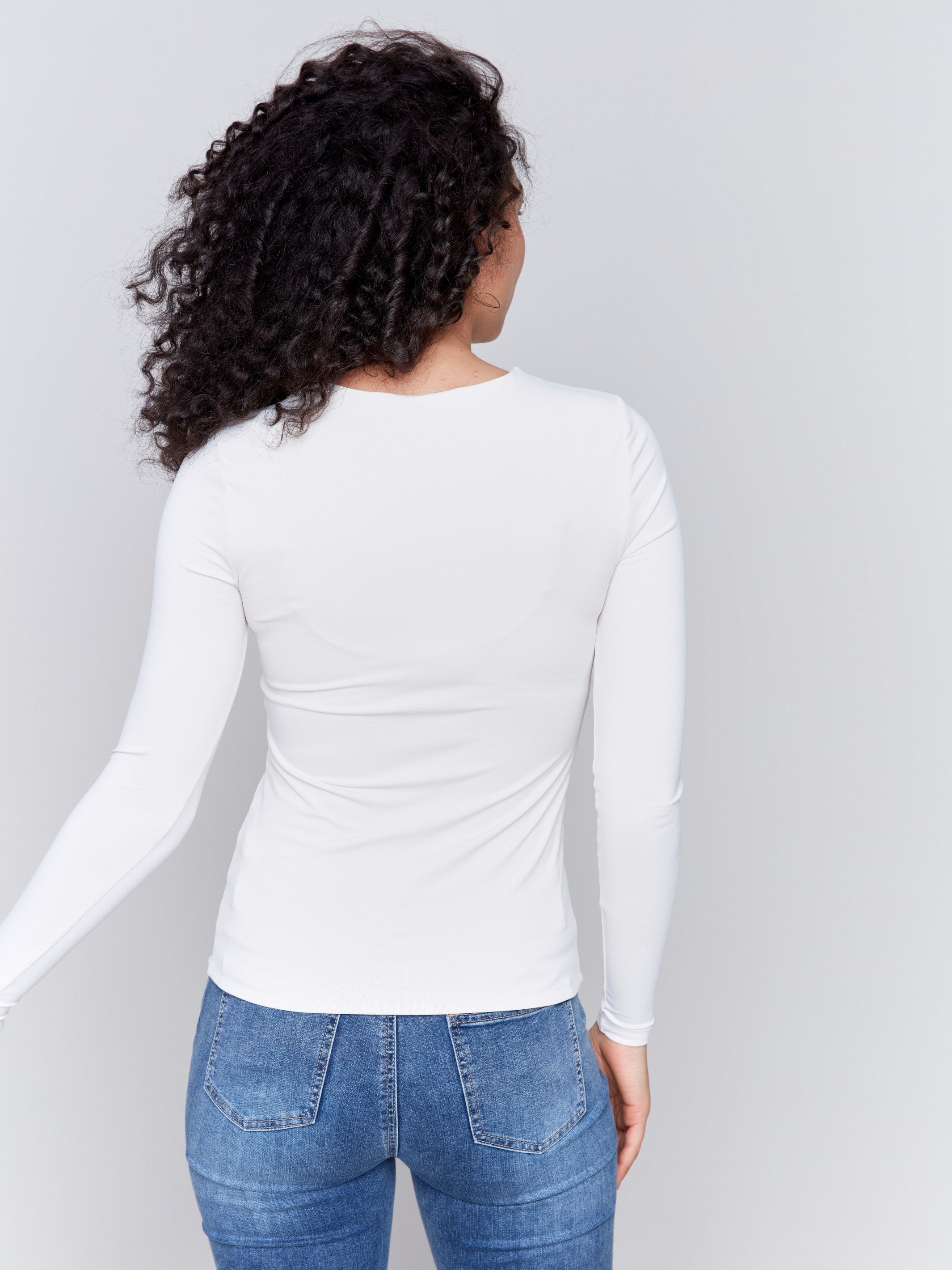 Natural white long-sleeve top with crew neckline, featuring a fitted silhouette by Charlie B.