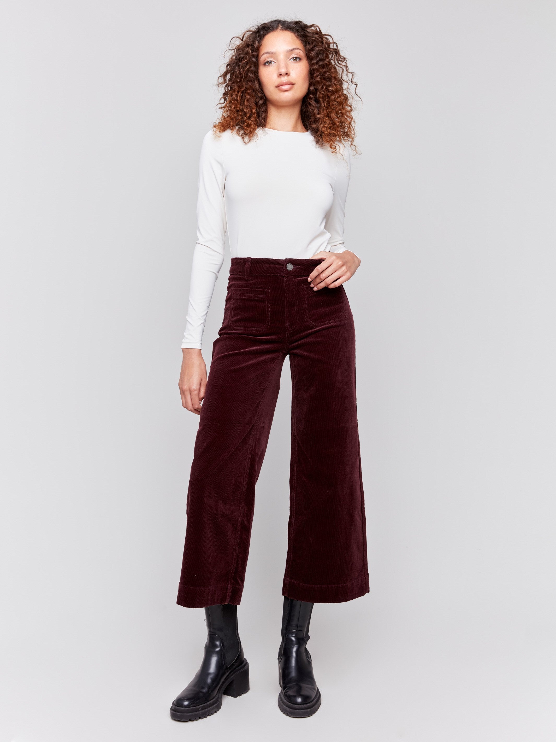 Plum purple corduroy flare pants with front and back patch pockets, a regular rise, and cropped design by Charlie B.