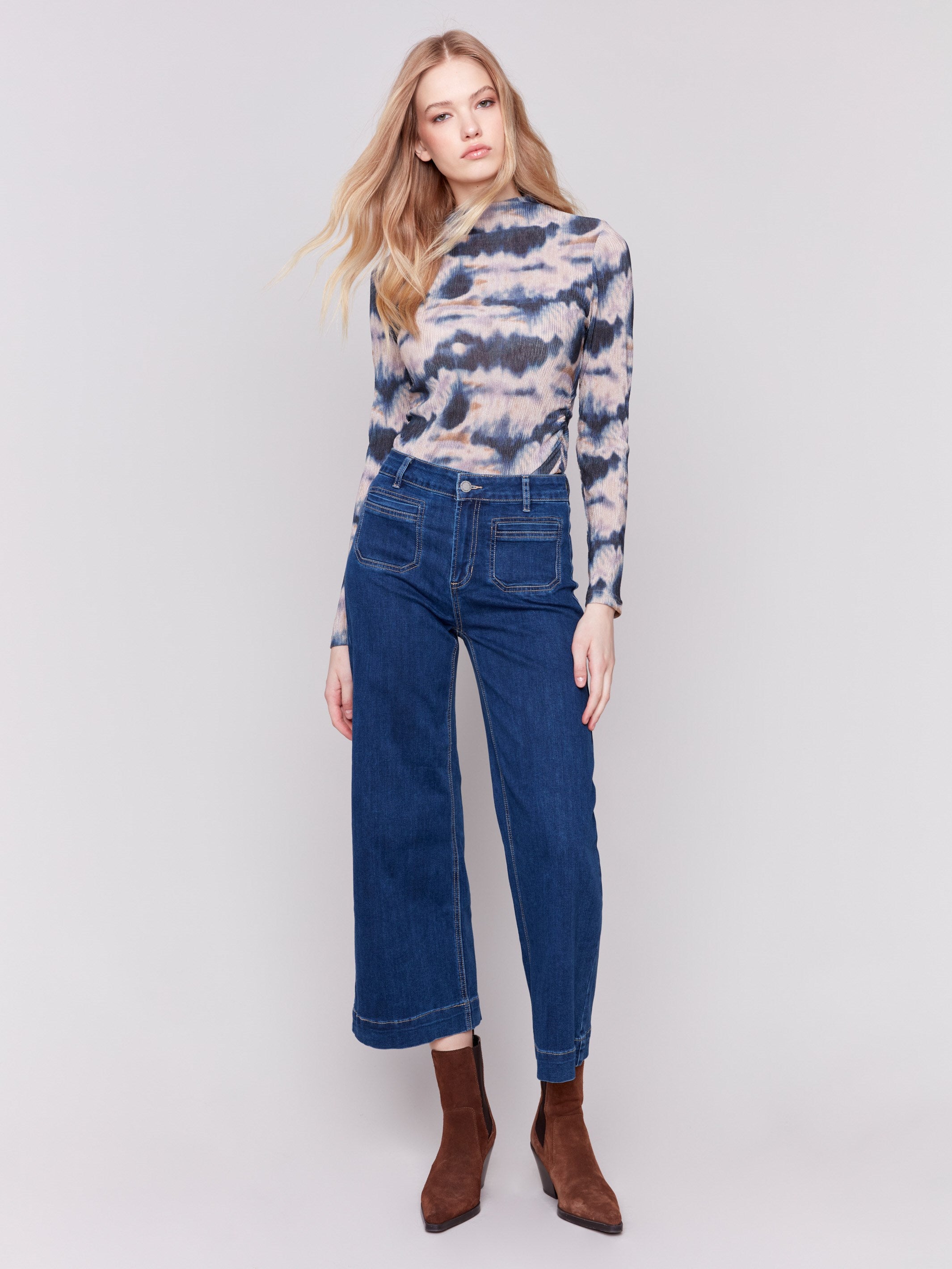 Indigo blue jeans with front patch pockets and a flared leg, featuring a mid-rise by Charlie B.