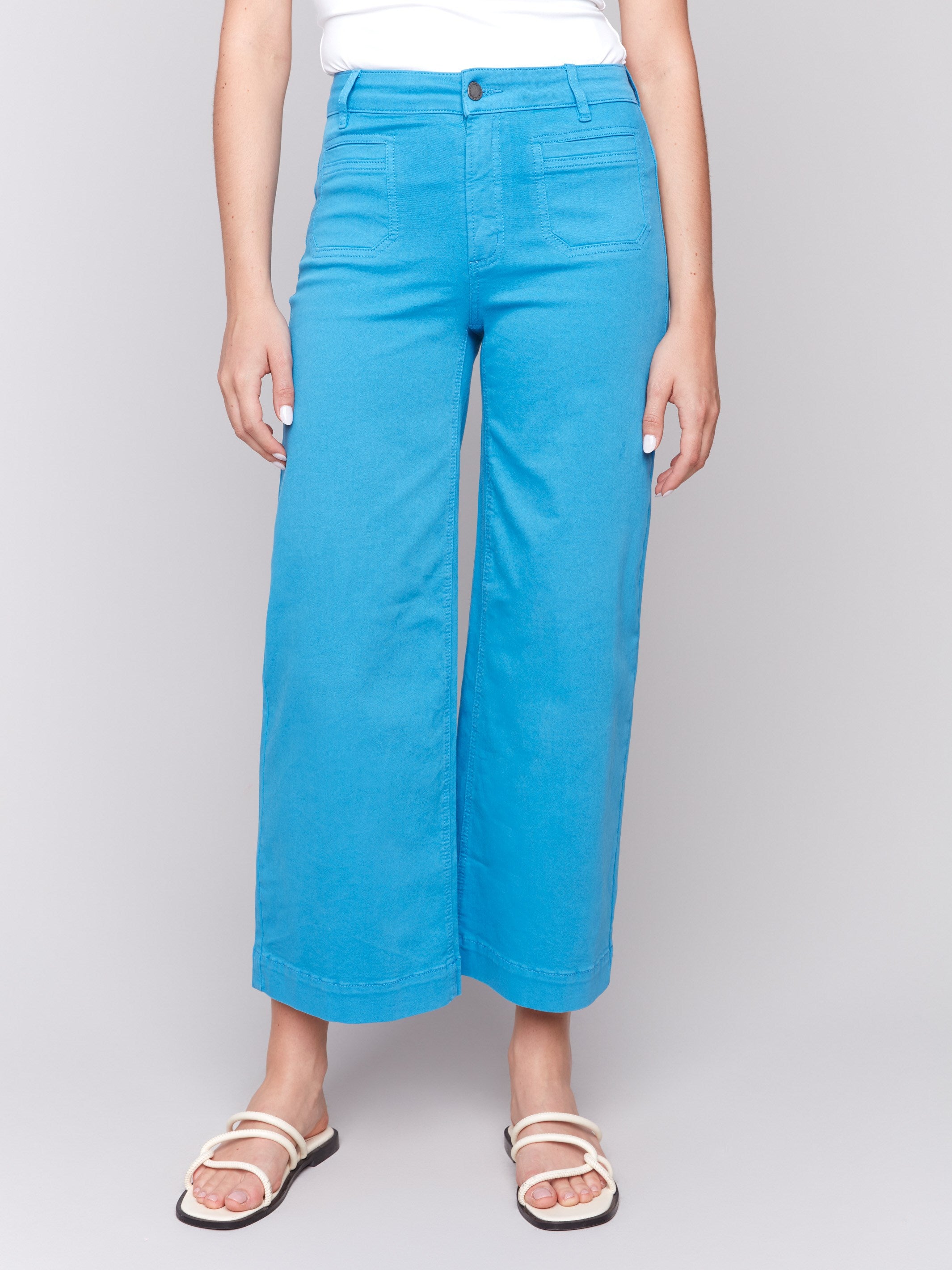 Blue flare twill pants featuring front patch pockets with a regular rise, button closure by Charlie B.