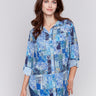 Blue printed blouse with button-front, featuring patch pockets and roll-up sleeves by Charlie B