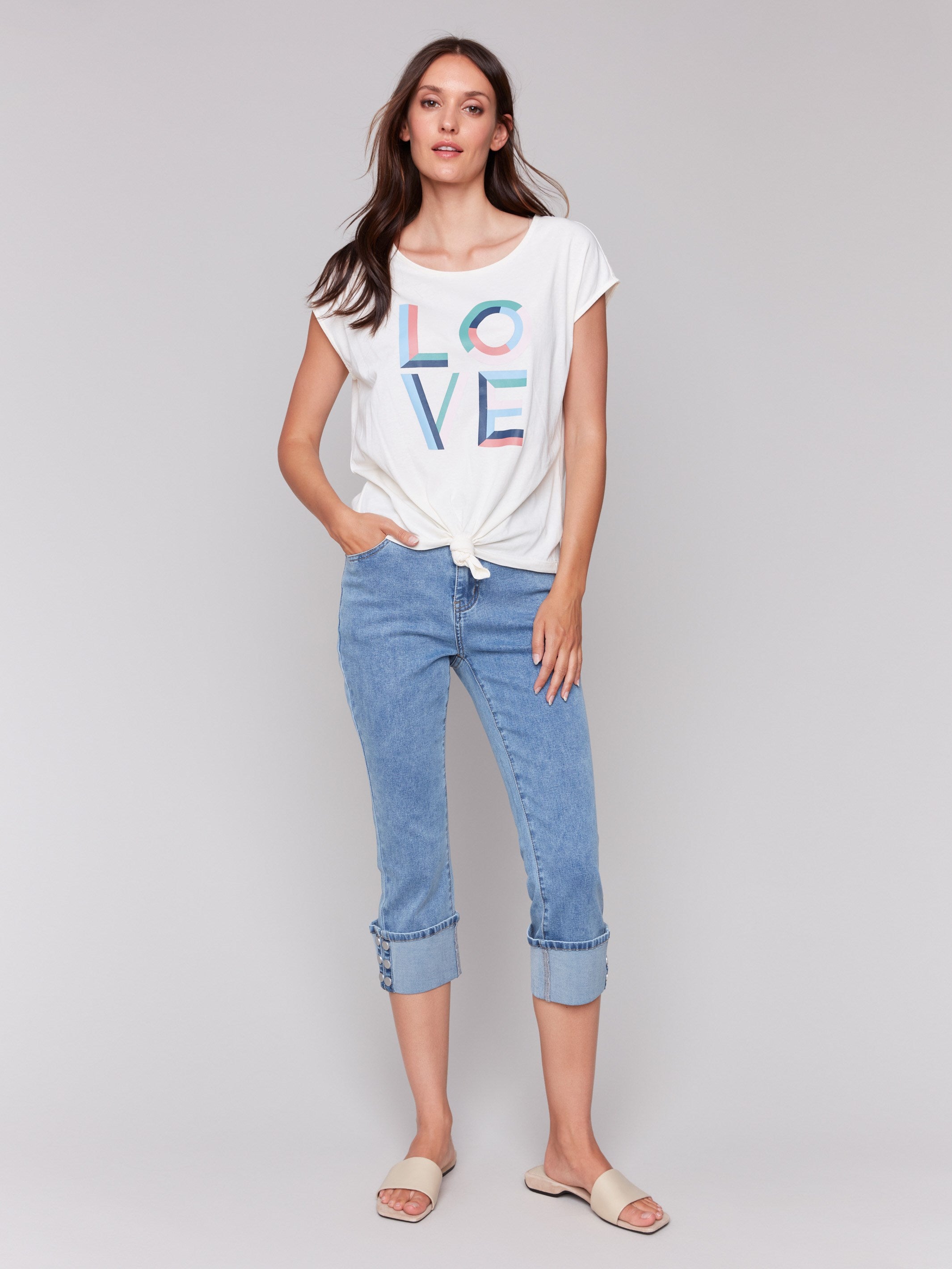 White sleeveless top with colorful 'LOVE' graphic print and a front-knot design by Charlie B.