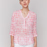 Geometric pattern blouse in begonia pink and white with a half-button front by Charlie B.