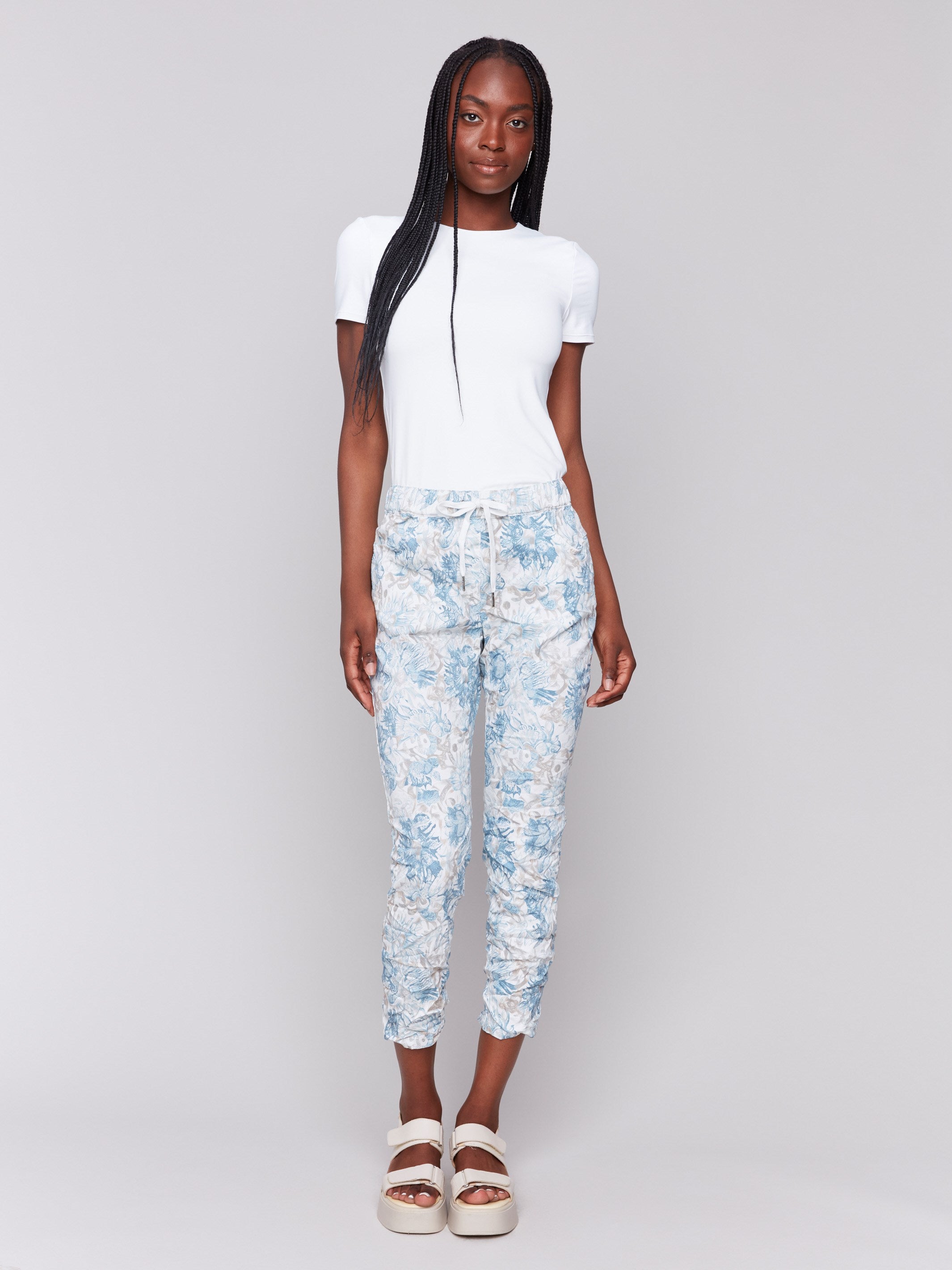 Blue and white jogger pants with a relaxed fit and floral print by Charlie B.