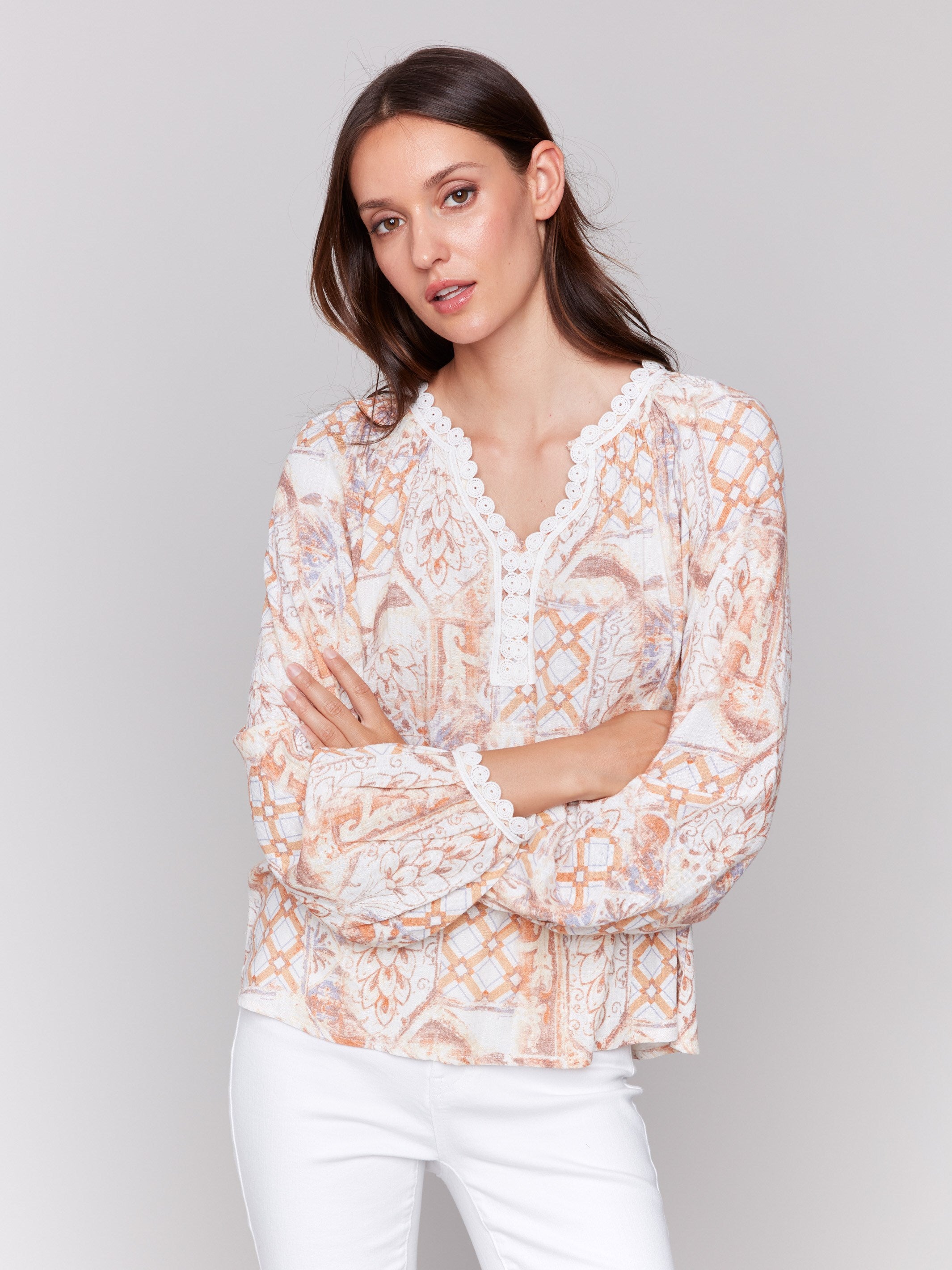 Papaya blouse with lace trim at neckline and cuffs, showcasing geometric floral prints by Charlie B.