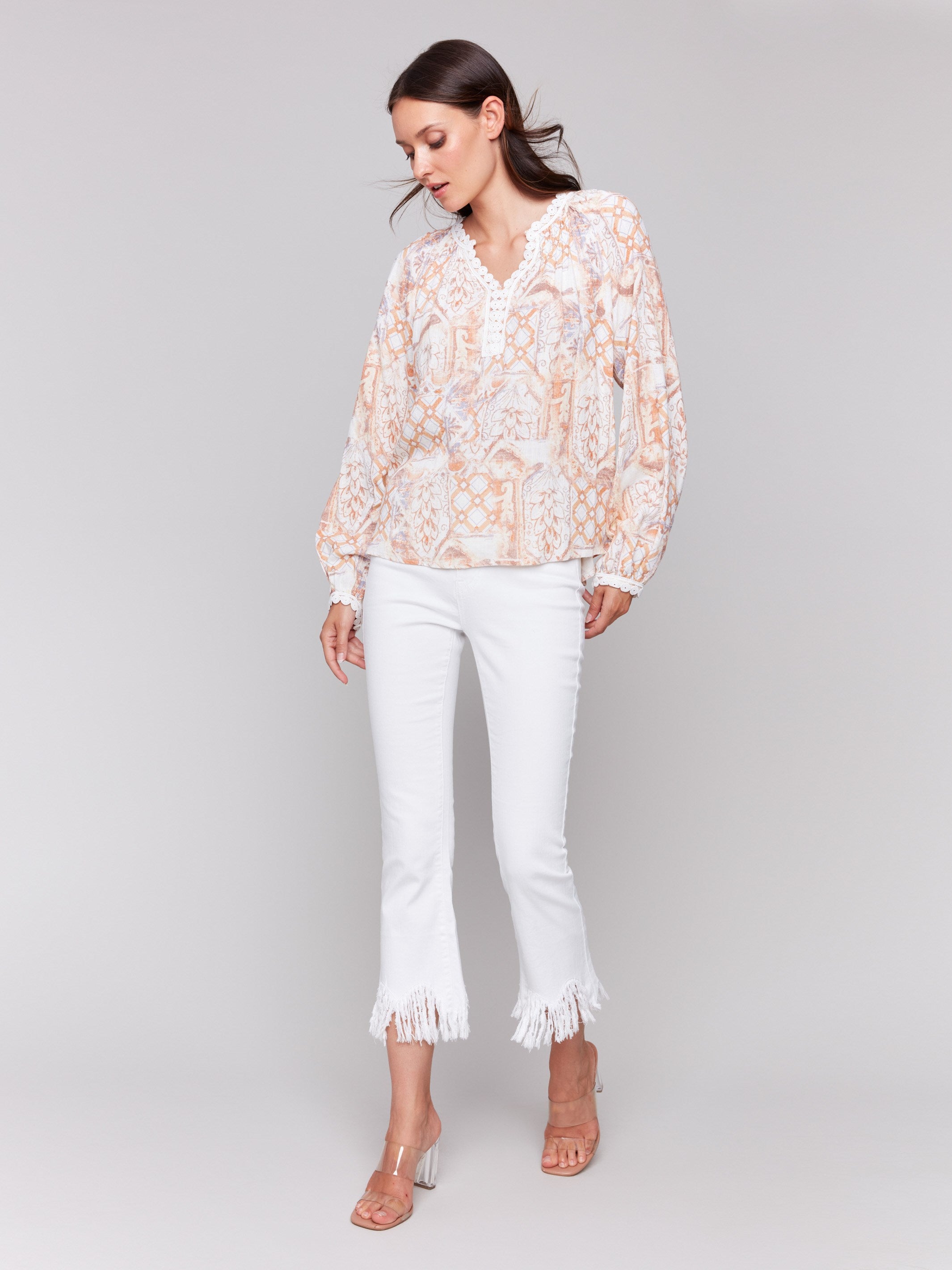 Papaya colored blouse featuring raglan long sleeves with intricate design details by Charlie B.