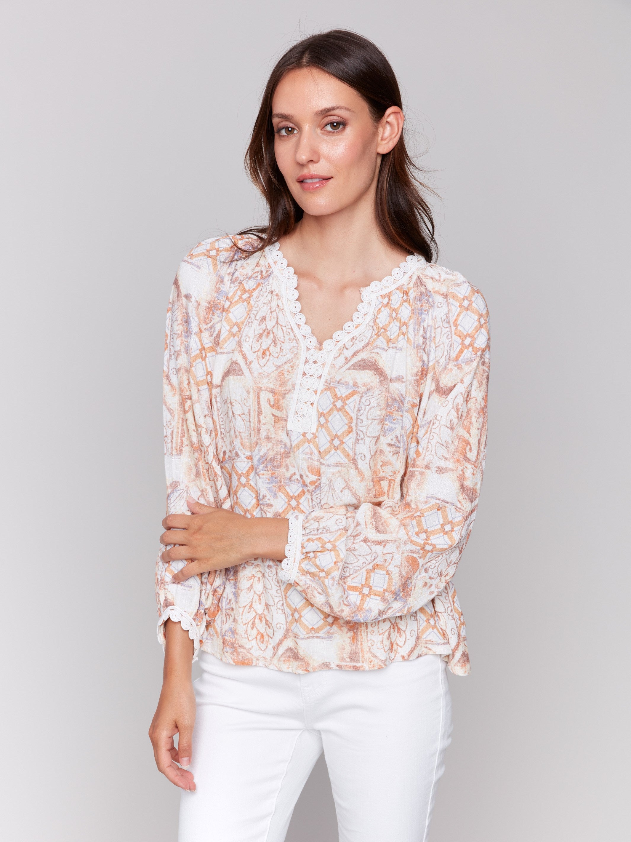 Blouse in papaya hue, highlighted by V-notch neckline and stylish patterns by Charlie B.