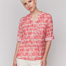 Red and white blouse with adjustable roll-up sleeves, featuring an abstract pattern by Charlie B.