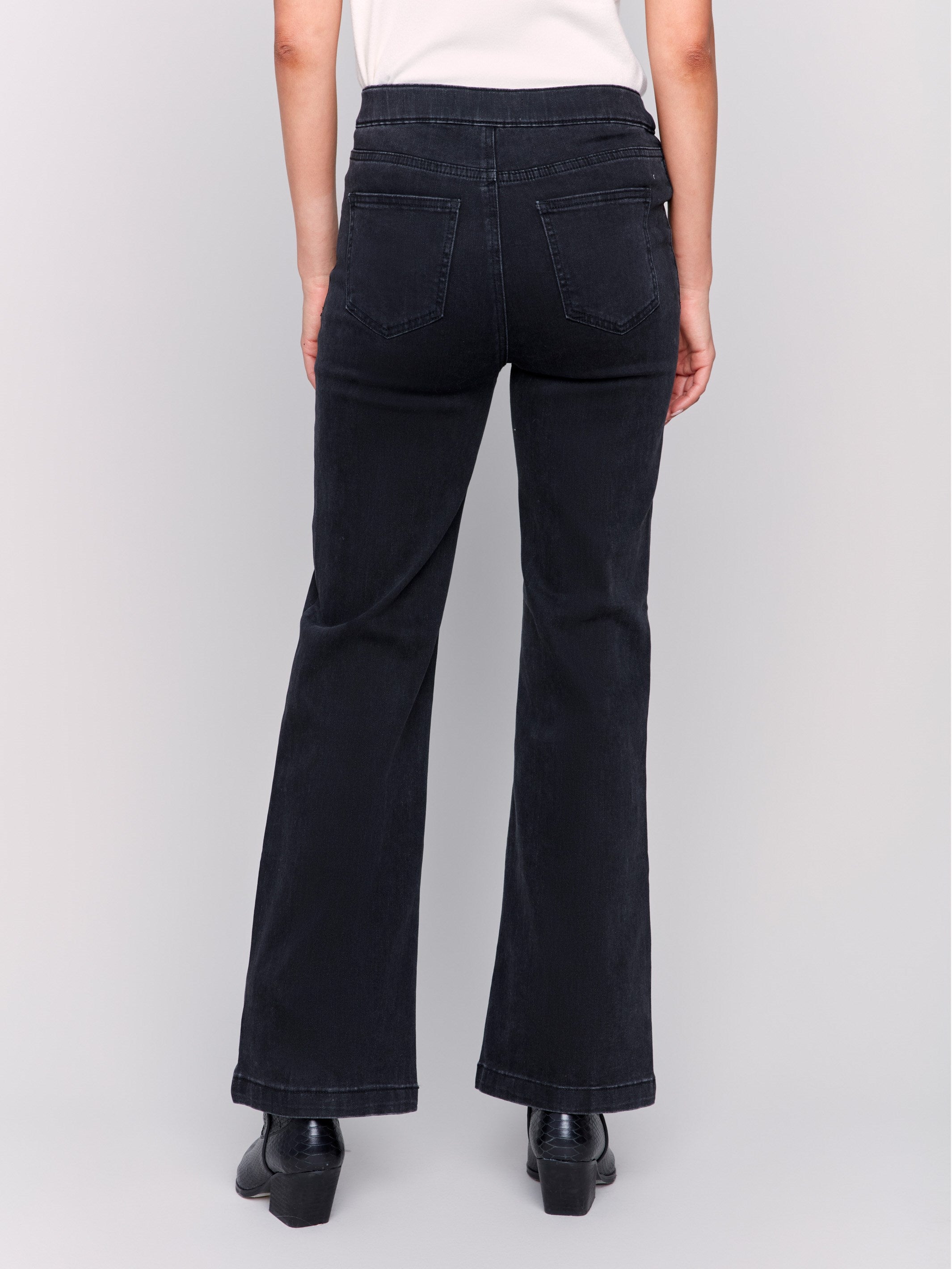 Charcoal black pull-on flare jeans featuring front button details, regular rise, and back pockets by Charlie B.