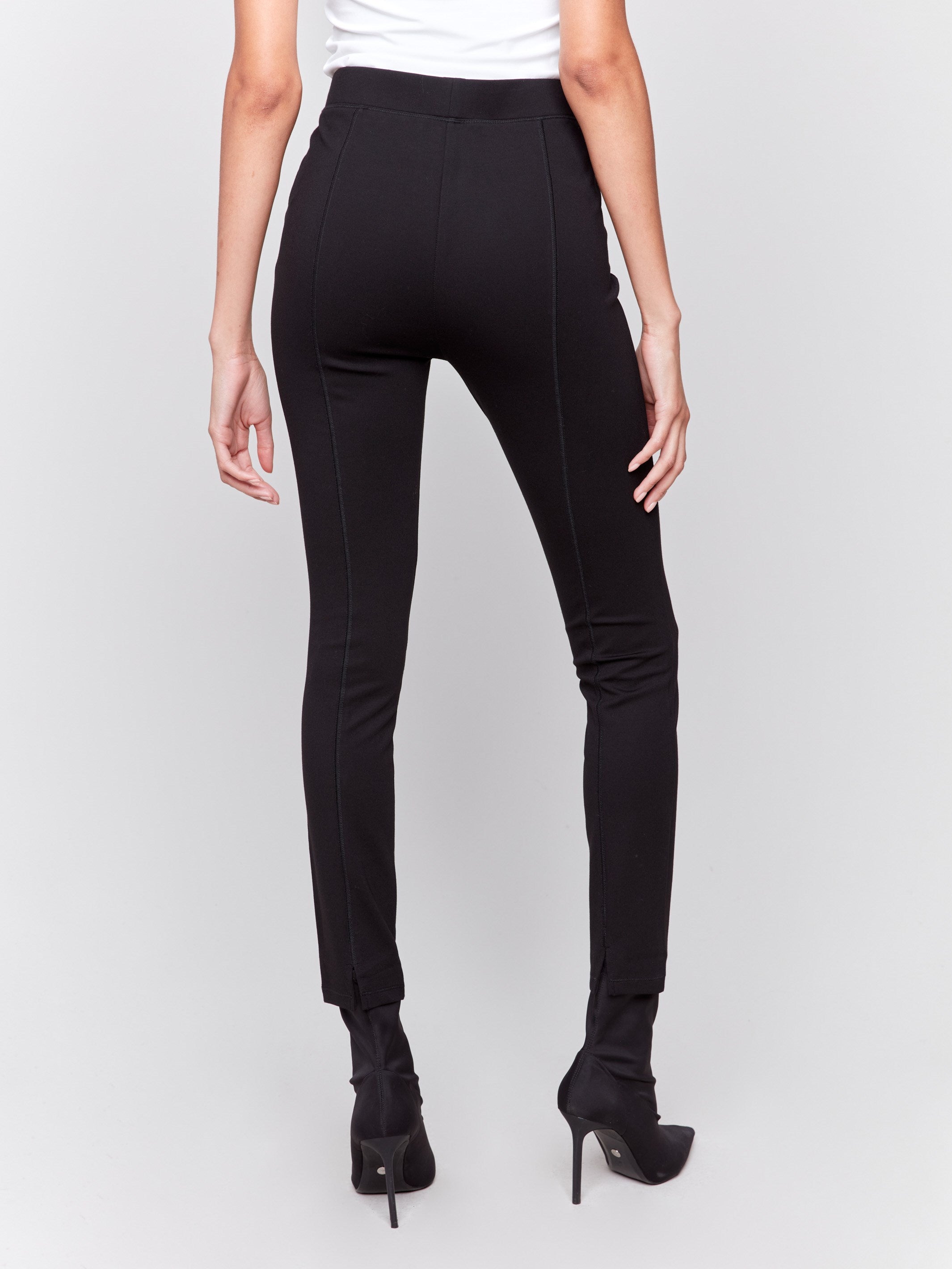 Black slim-leg pants with a regular rise, featuring a slit detail and an elastic waistband by Charlie B.