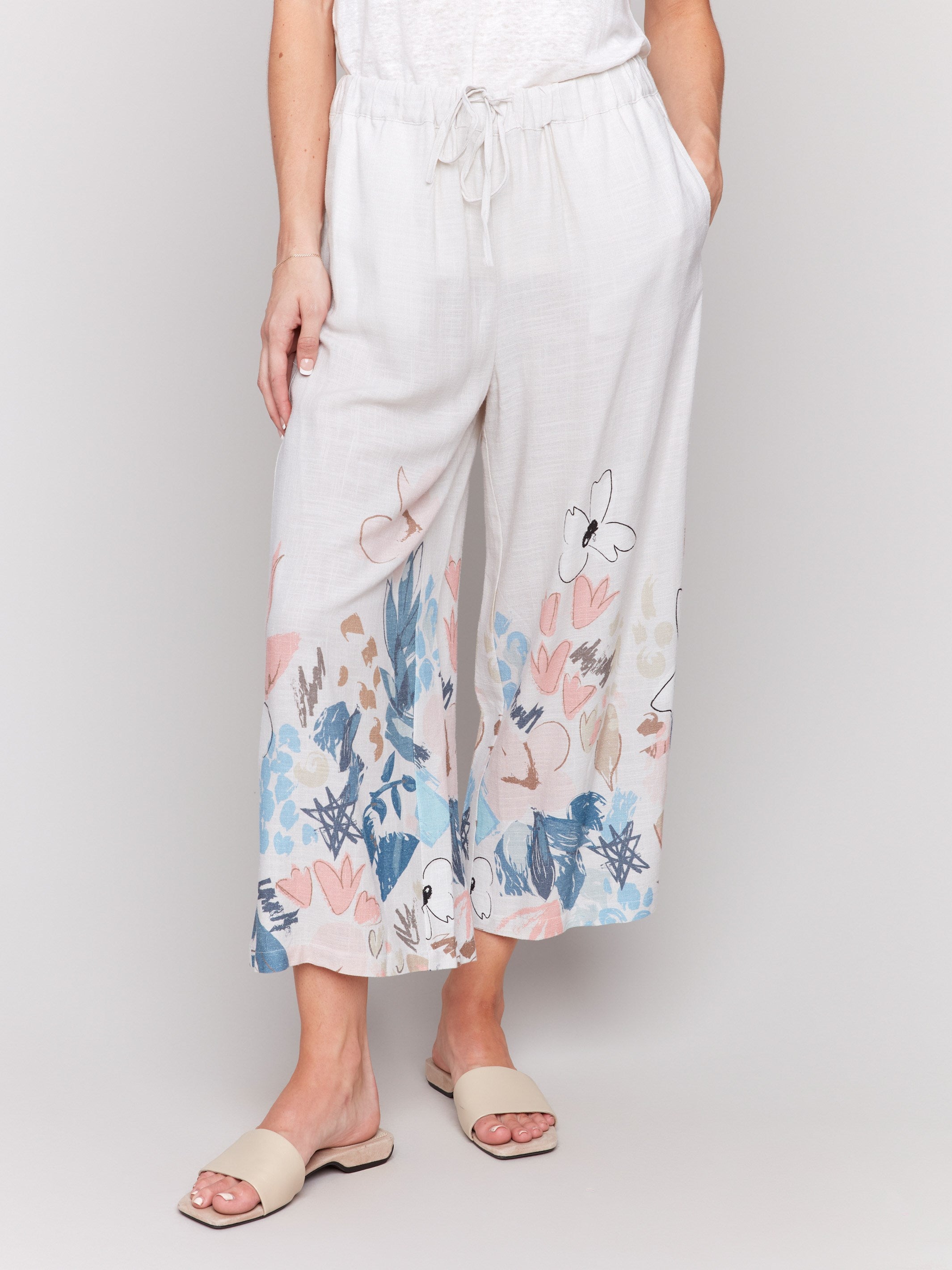 Cropped pants featuring a drawstring waistband and vibrant floral design by Charlie B.